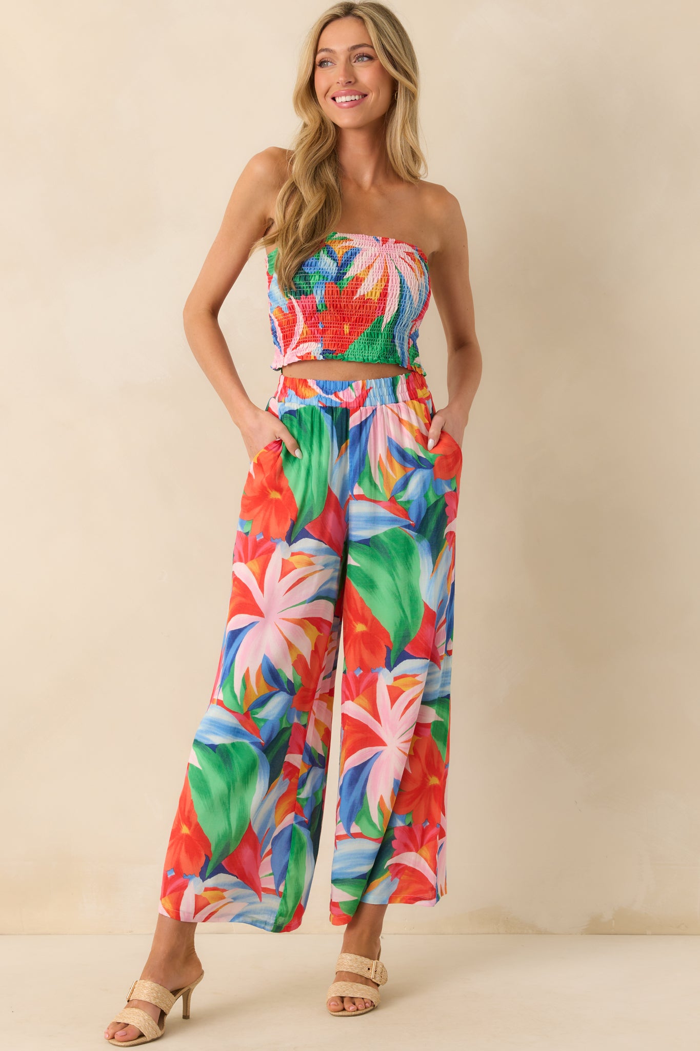 Angled full body image capturing the cropped length and fitted silhouette of the fully smocked floral top.