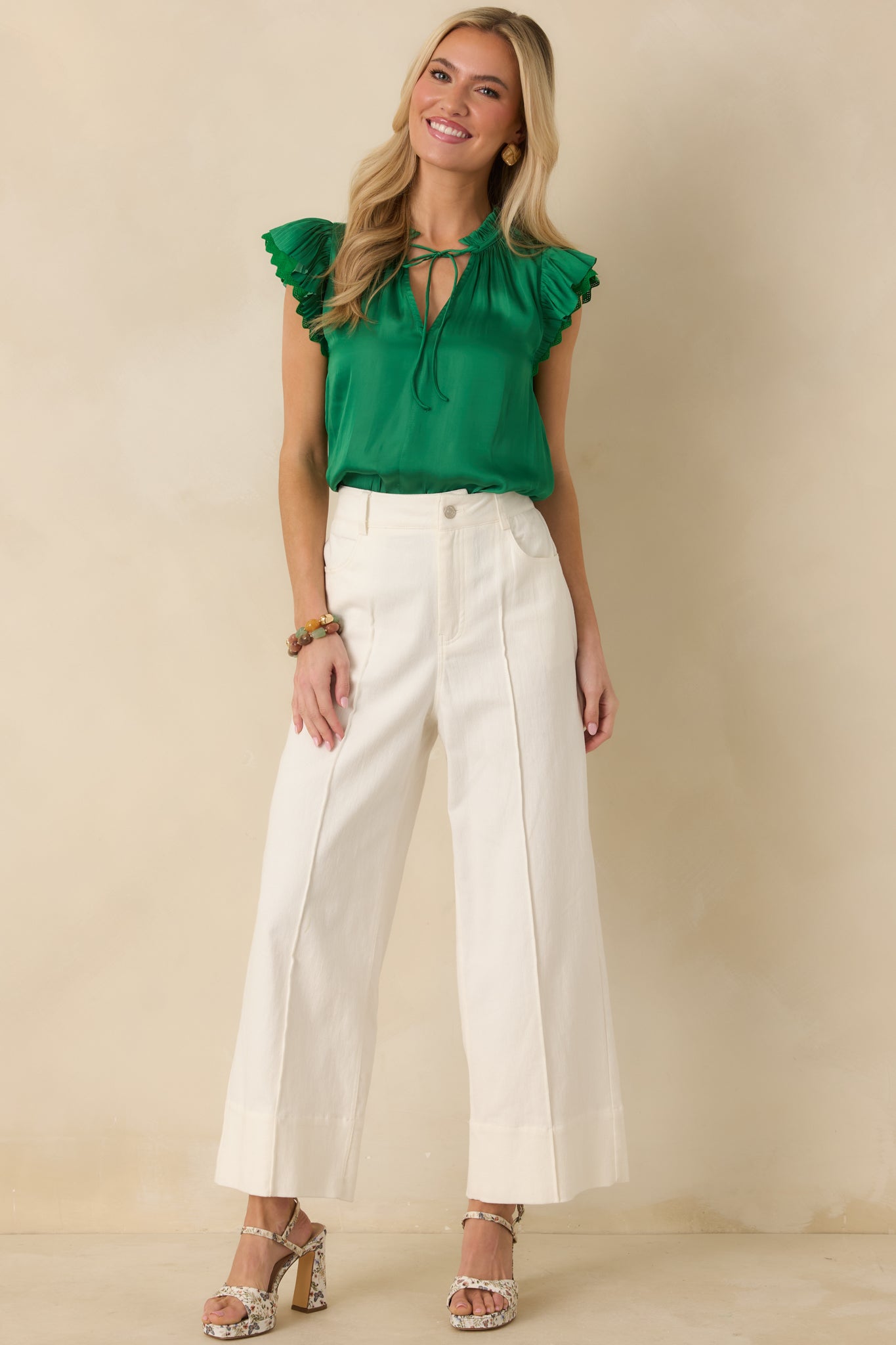Full-length front view of the green blouse highlighting the V-neckline, adjustable tie detail, and airy drape.