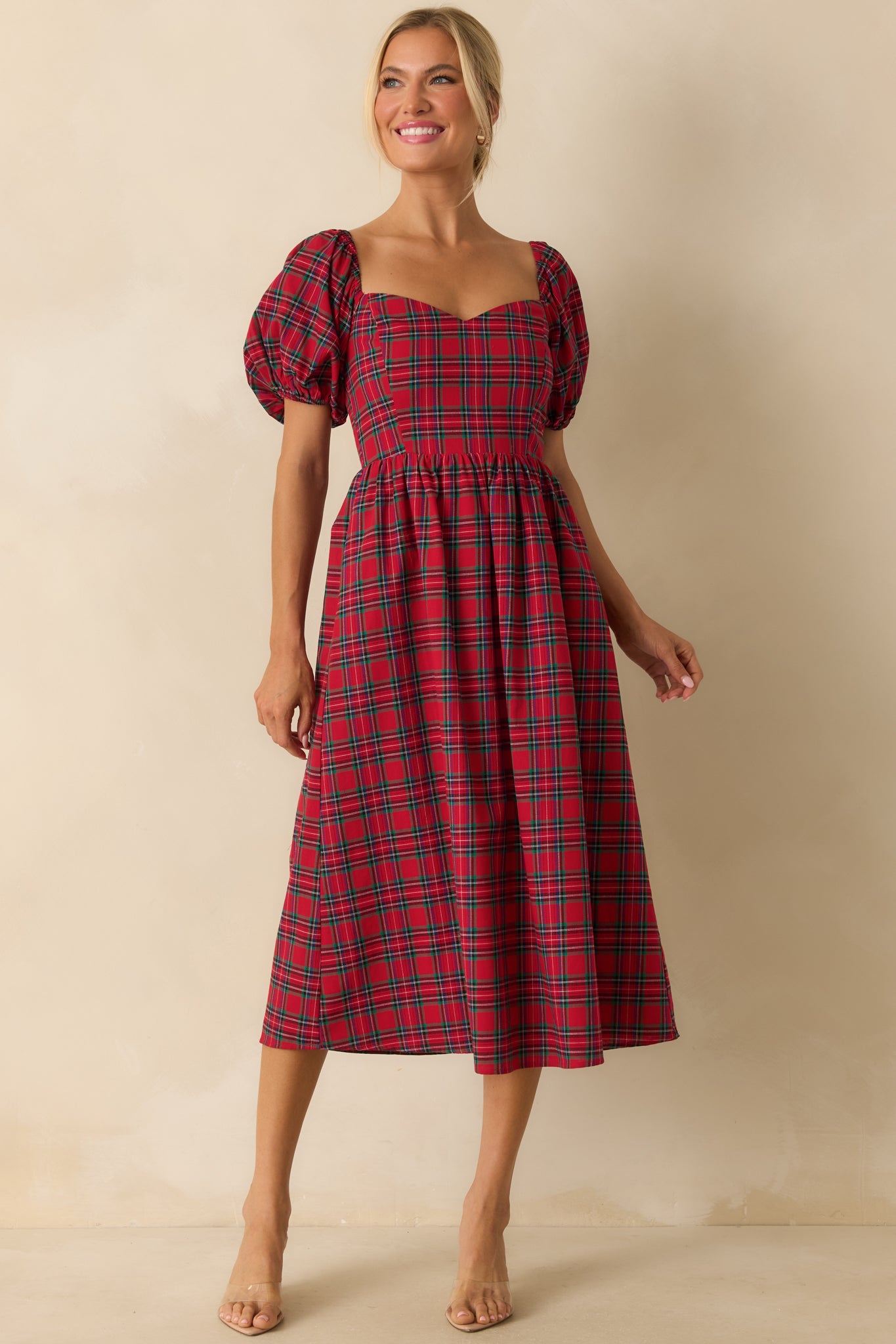 Full-length front view of red plaid dress featuring a sweetheart neckline, short puff sleeves, fitted bodice, and subtle plaid pattern.