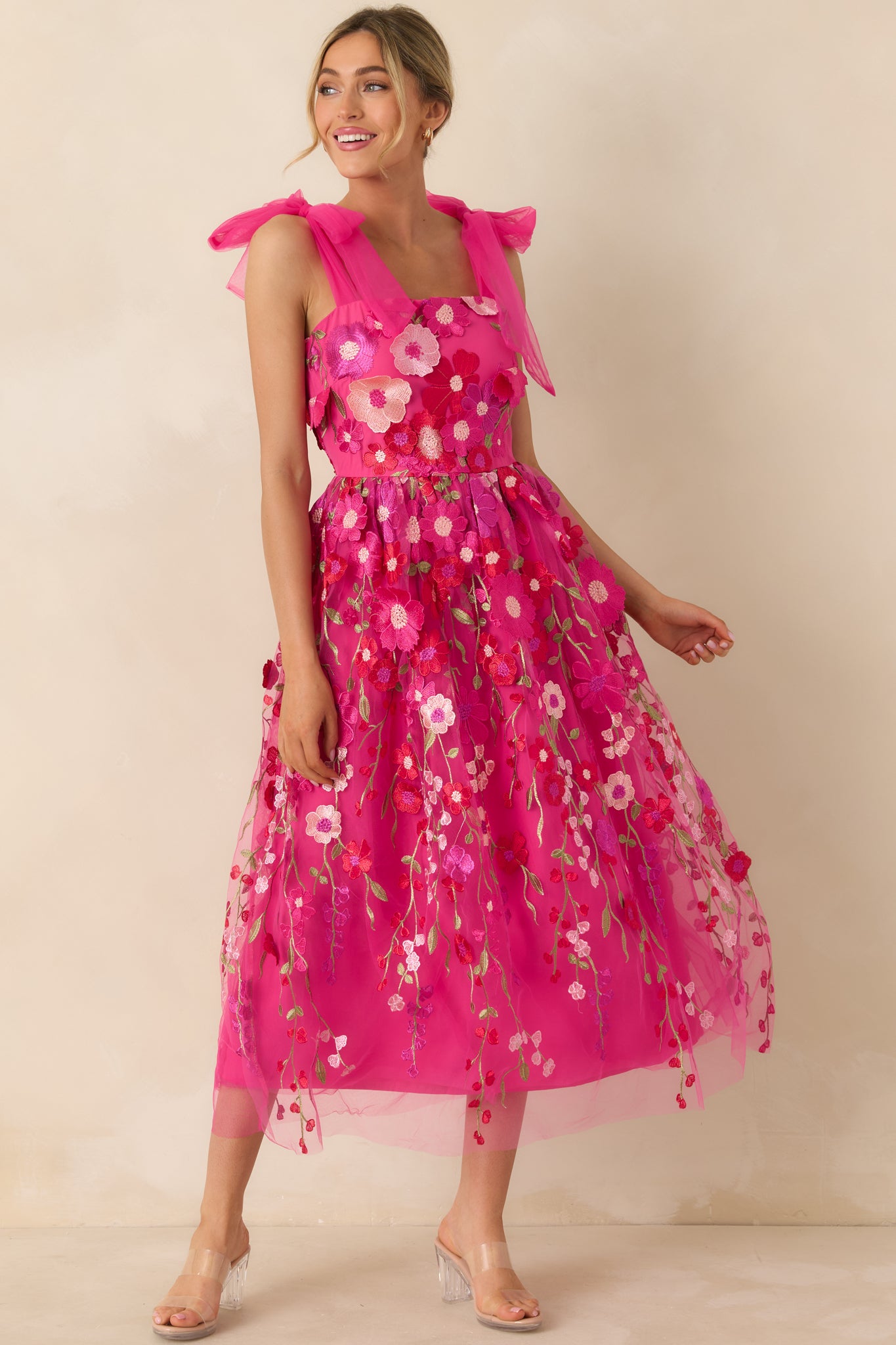 Full-length front view of the fuchsia pink dress highlighting the three-dimensional floral appliqués and straight neckline.