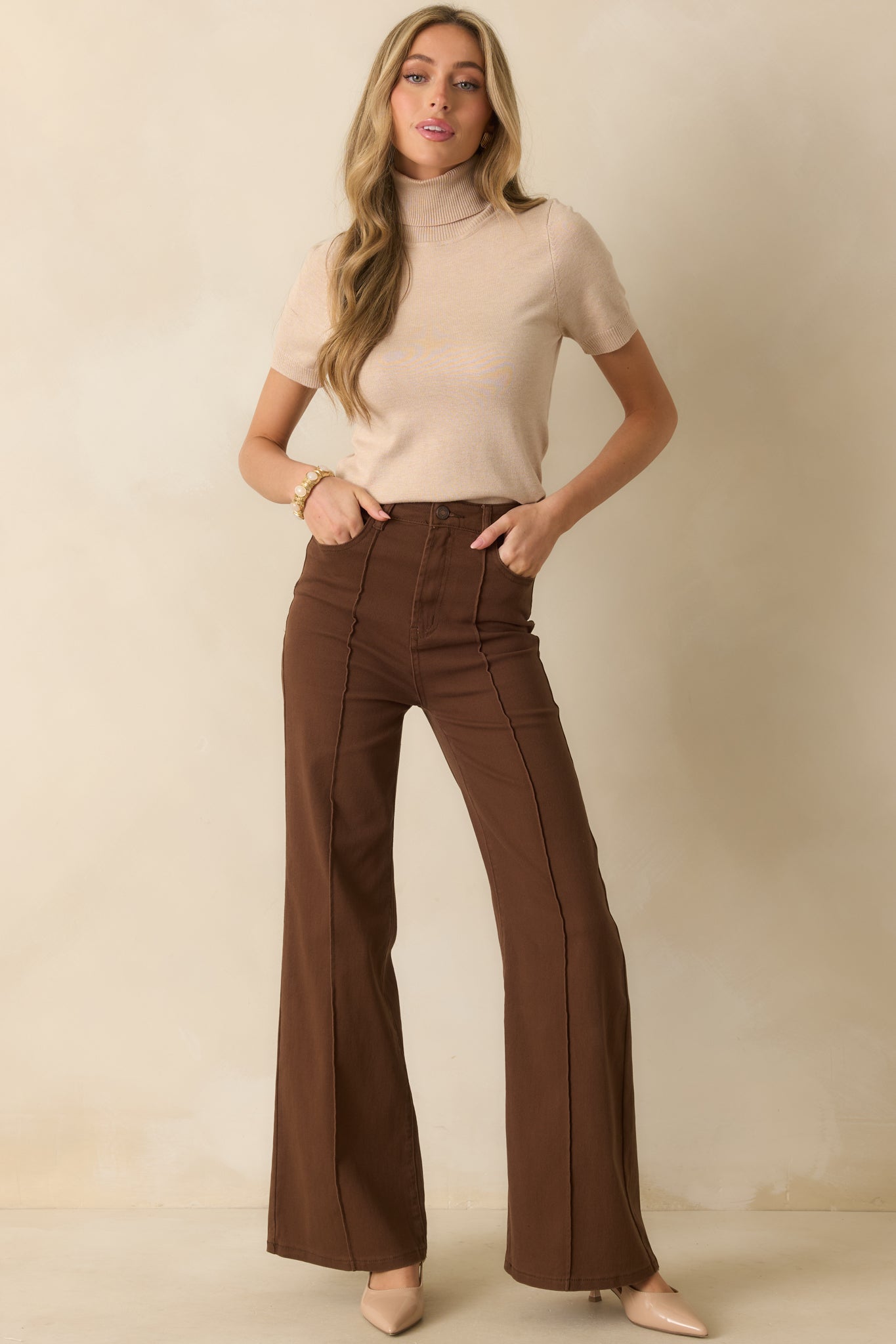 A full-length view highlighting the classic five-pocket design and belt loops on the brown jeans.