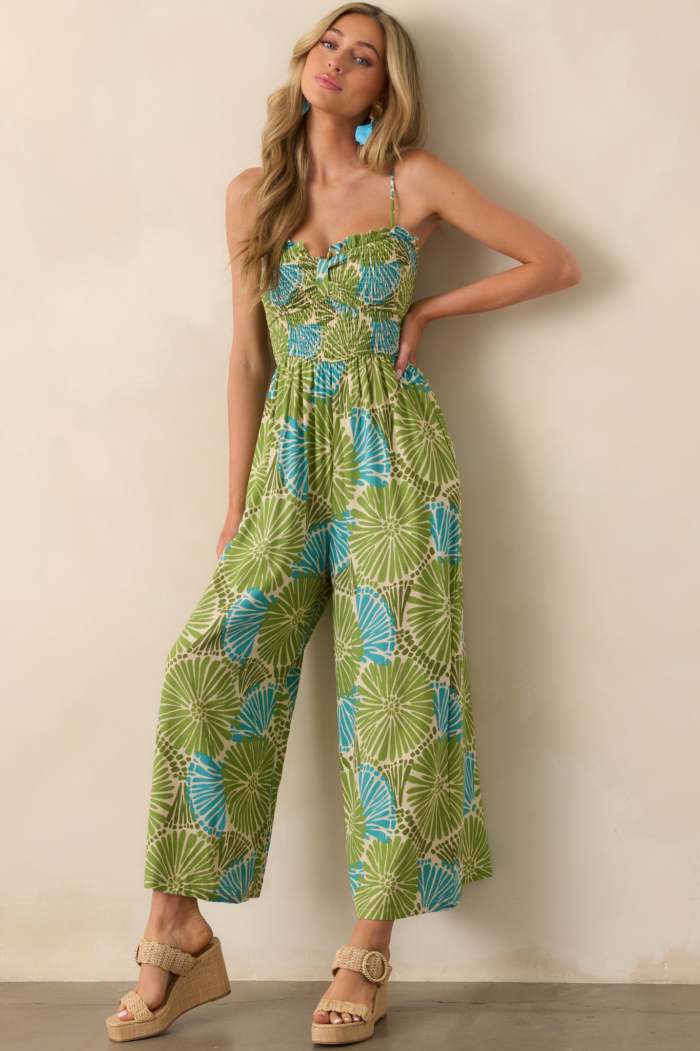 Full-length view of a green and blue floral jumpsuit with wide legs and a sweetheart neckline.