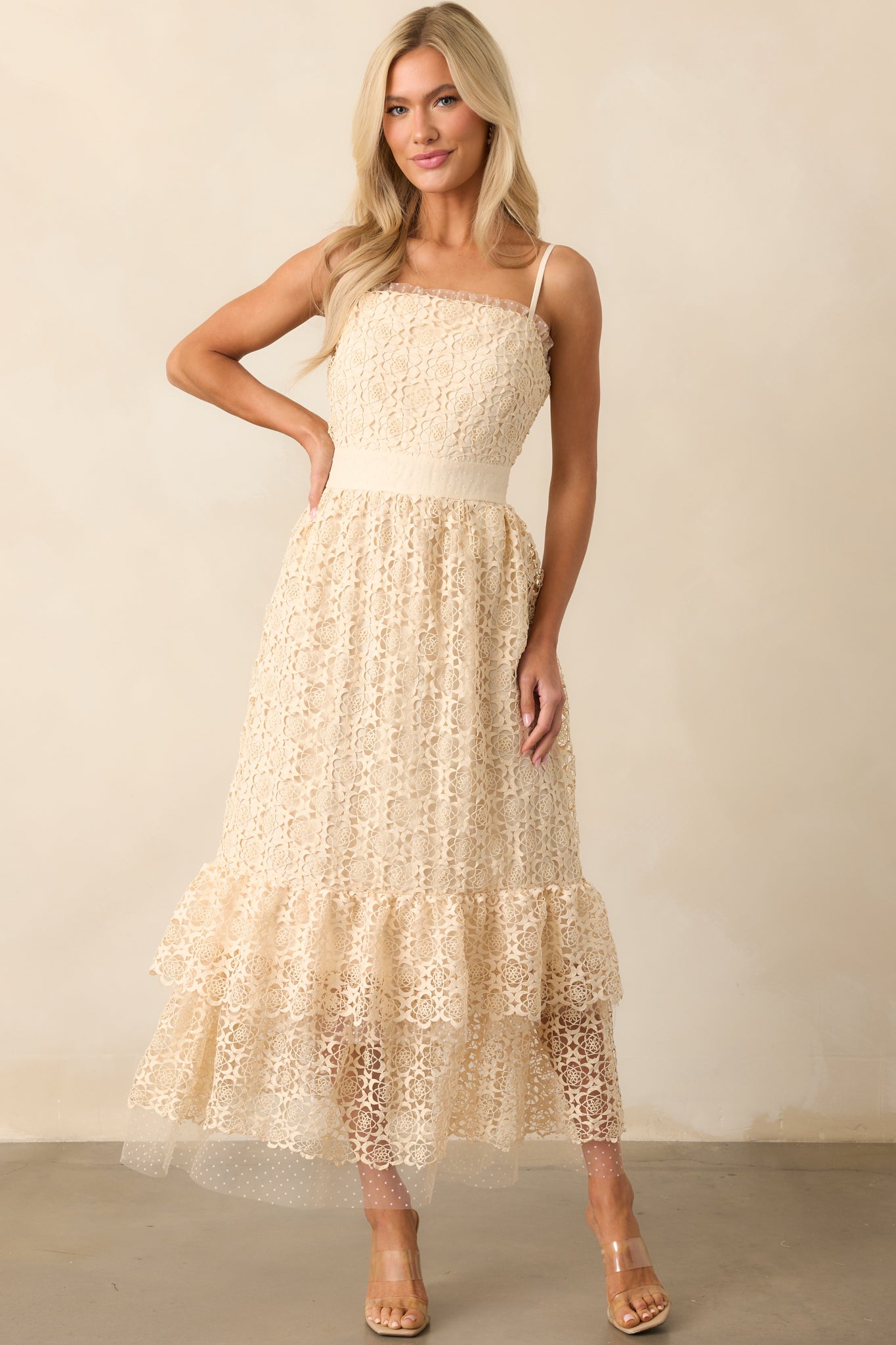 A full-length shot showcasing the embroidered design and tiered bottom layers of the natural-colored midi dress.