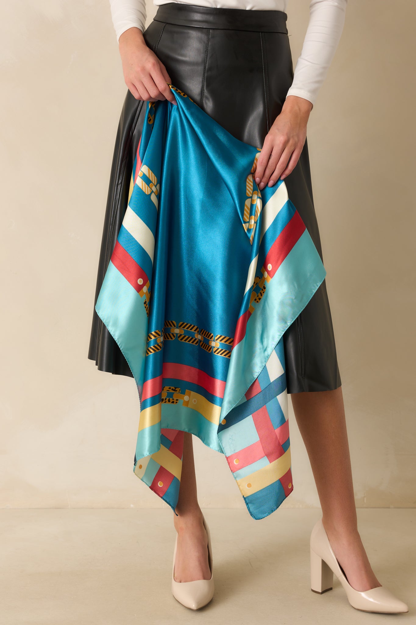 Full view of blue satin scarf with pink and gold chain print and multicolor accents along the edges.