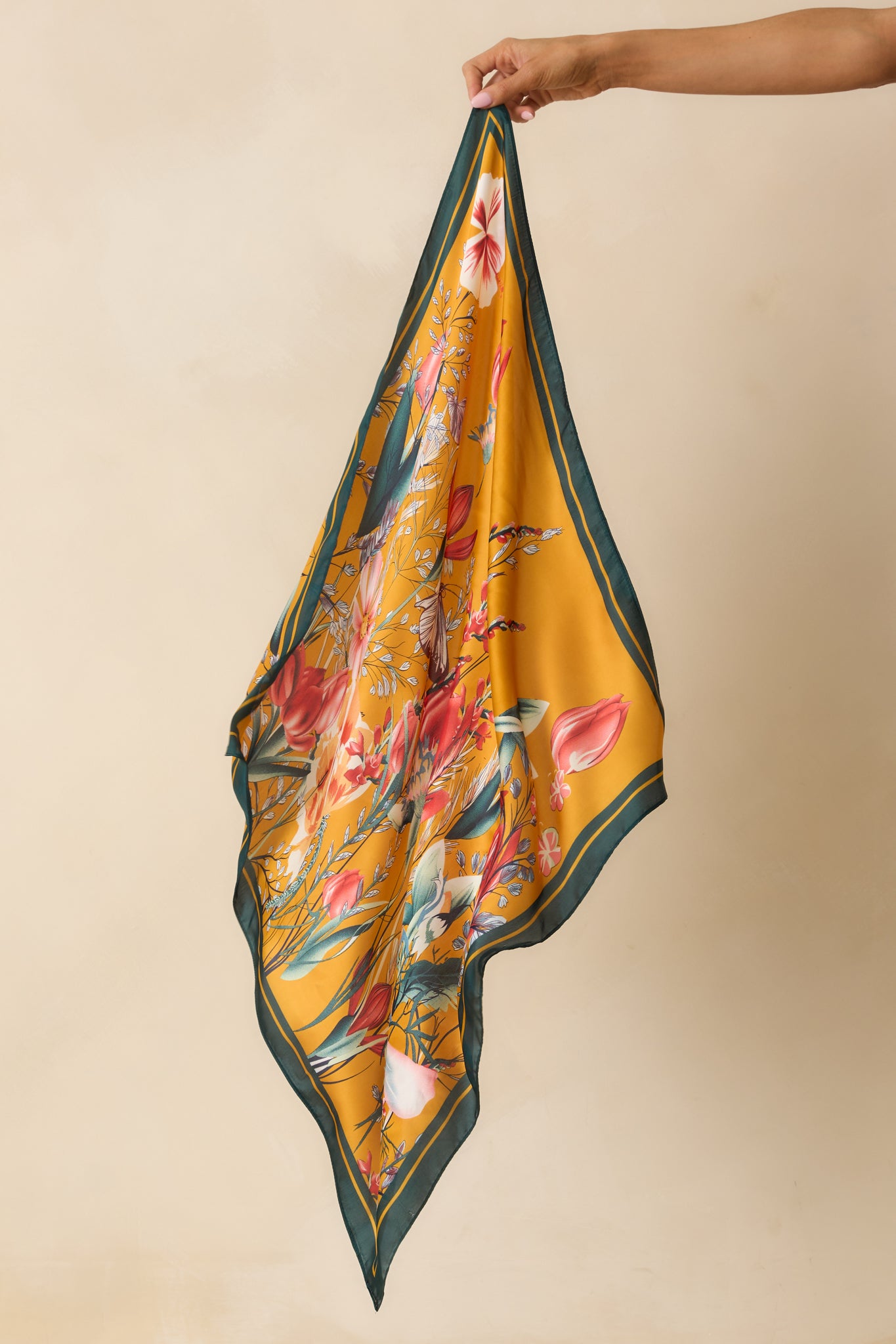 A full view of the green floral scarf with a flower field print and solid green border.