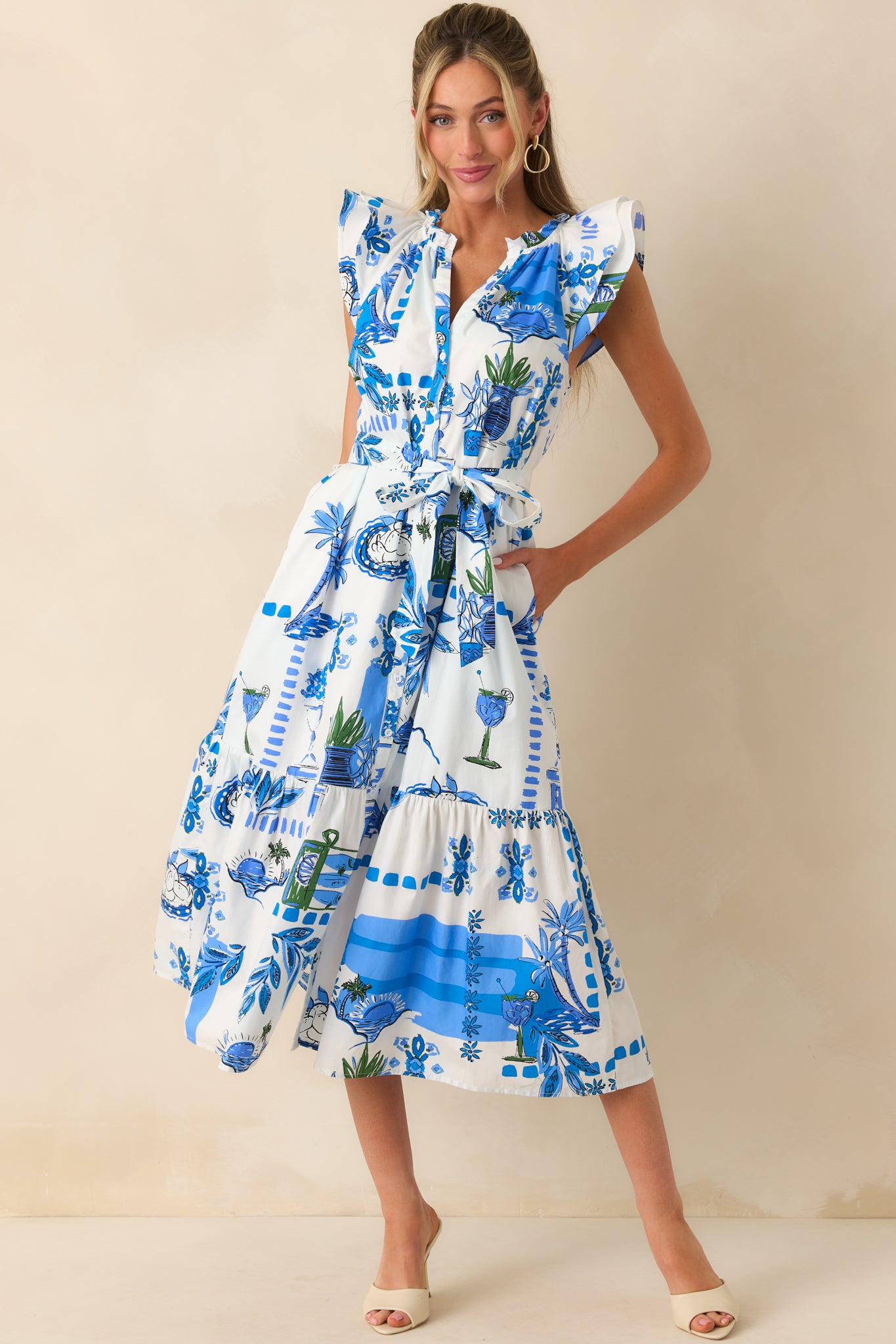 Full body view of the maxi dress highlighting the blue tropical Sicilian-inspired print and ruffle notch v-neckline.