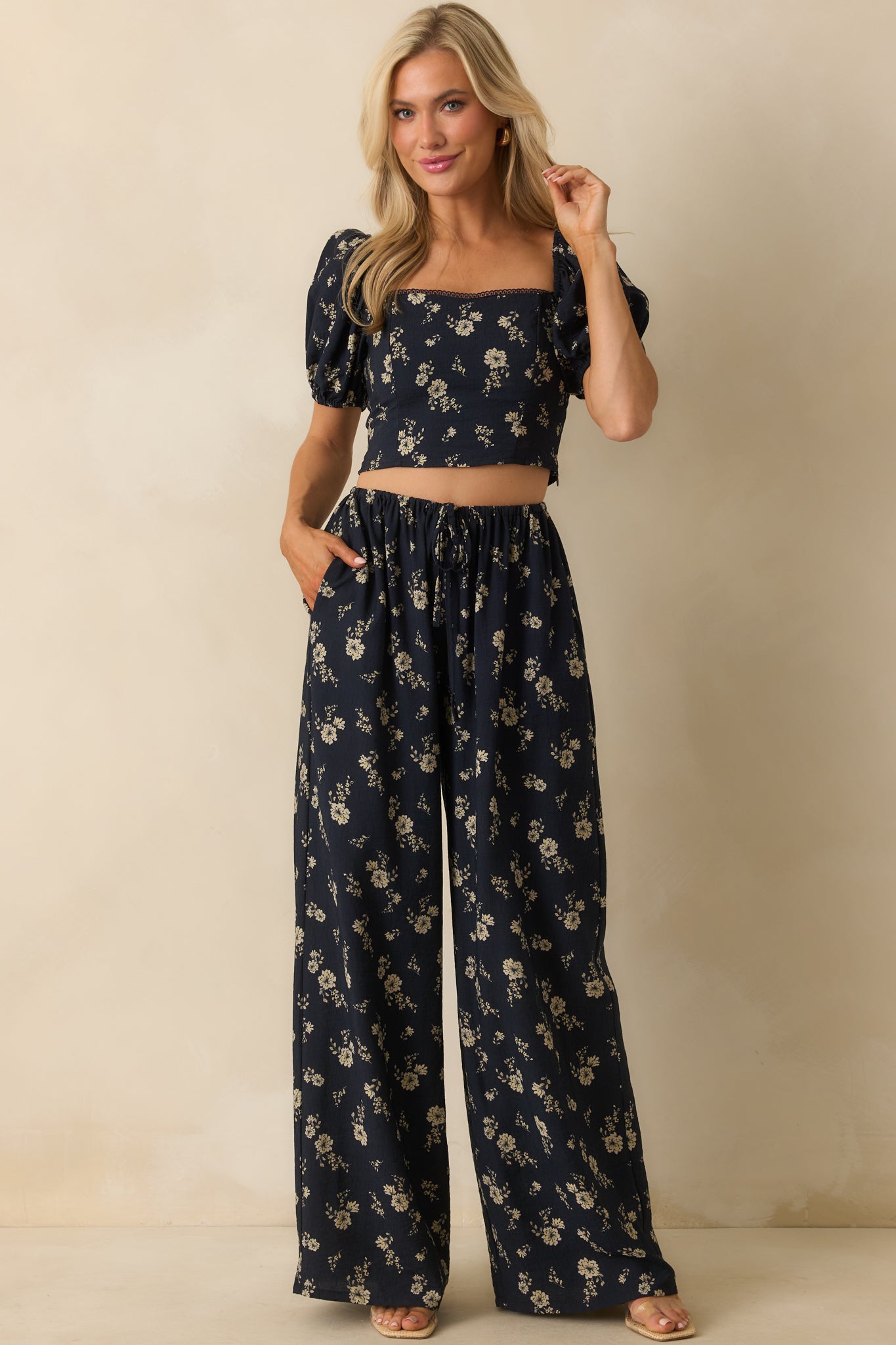 Full view of the navy pants with ivory floral print, high-rise waist, and wide-leg silhouette.