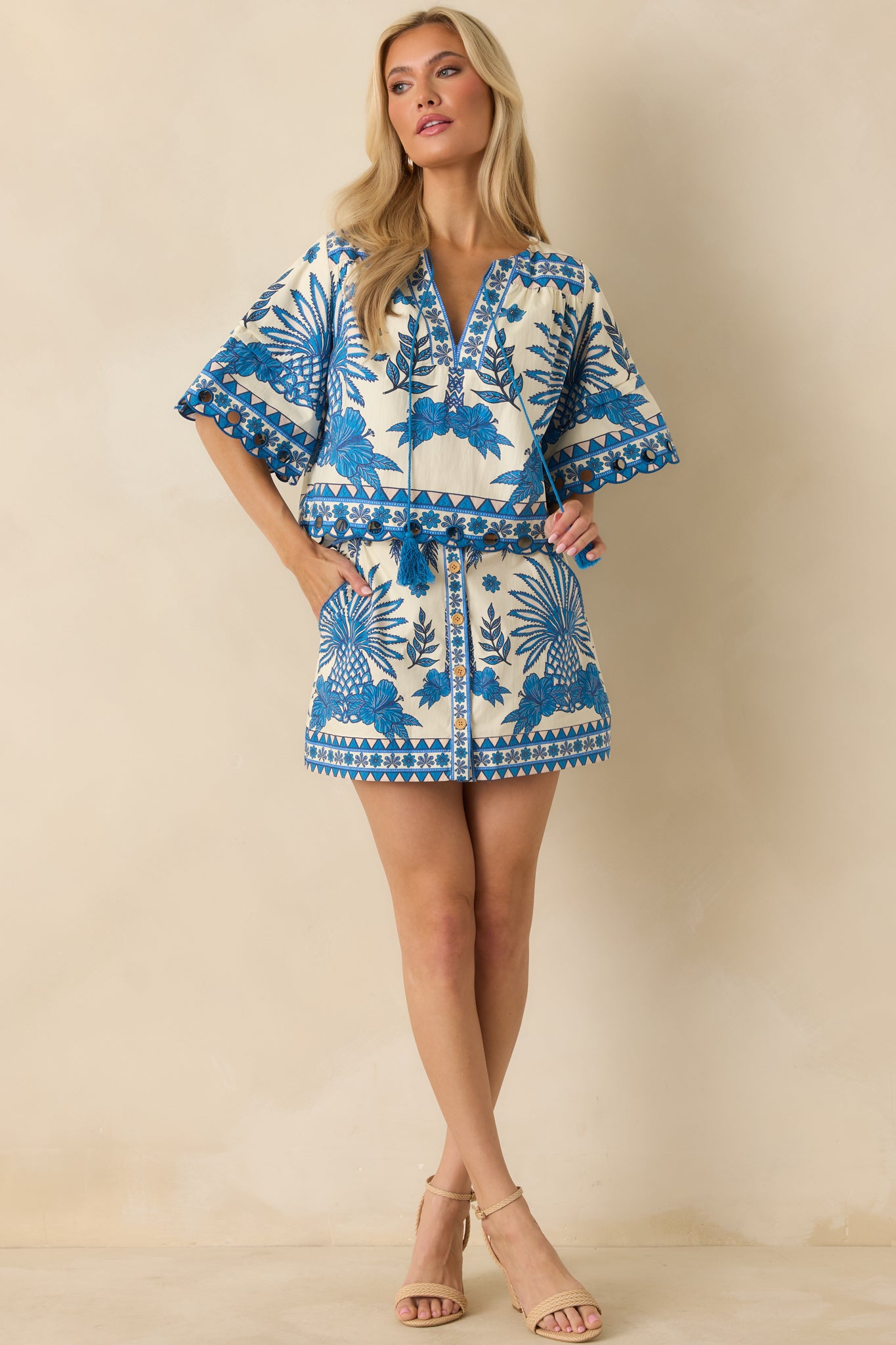 Full front view of blue and ivory cotton mini skirt with tropical print and button-front closure.