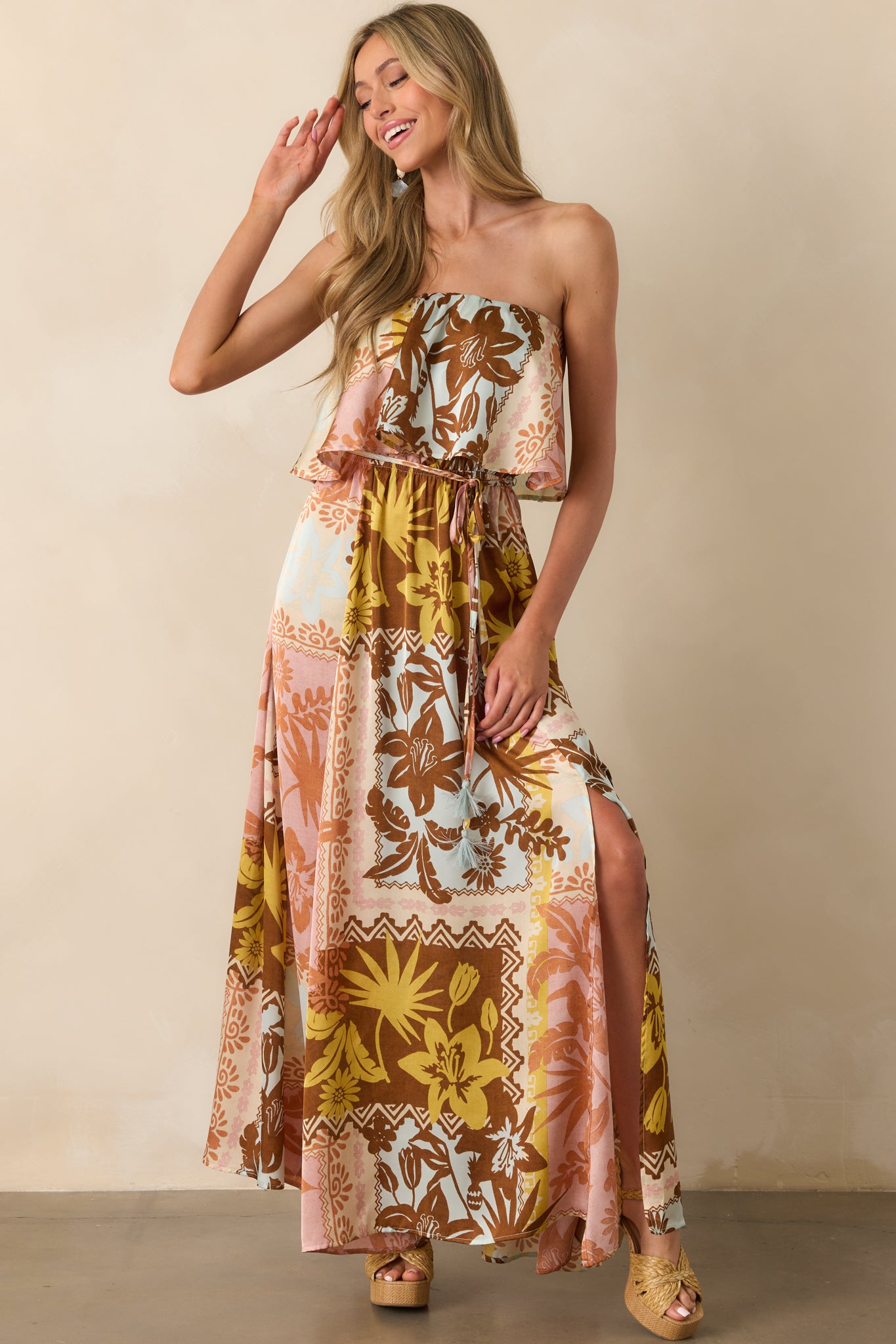 Full body front-facing view highlighting the strapless flounce neckline, multicolor patchwork print, and the side slit revealing a subtle glimpse of movement in the maxi-length skirt.