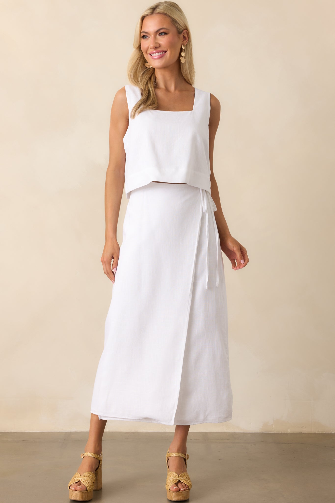 Full body front view of the white midi skirt showing the wrap design, high rise fit, and adjustable self-tie belt secured at the waist.