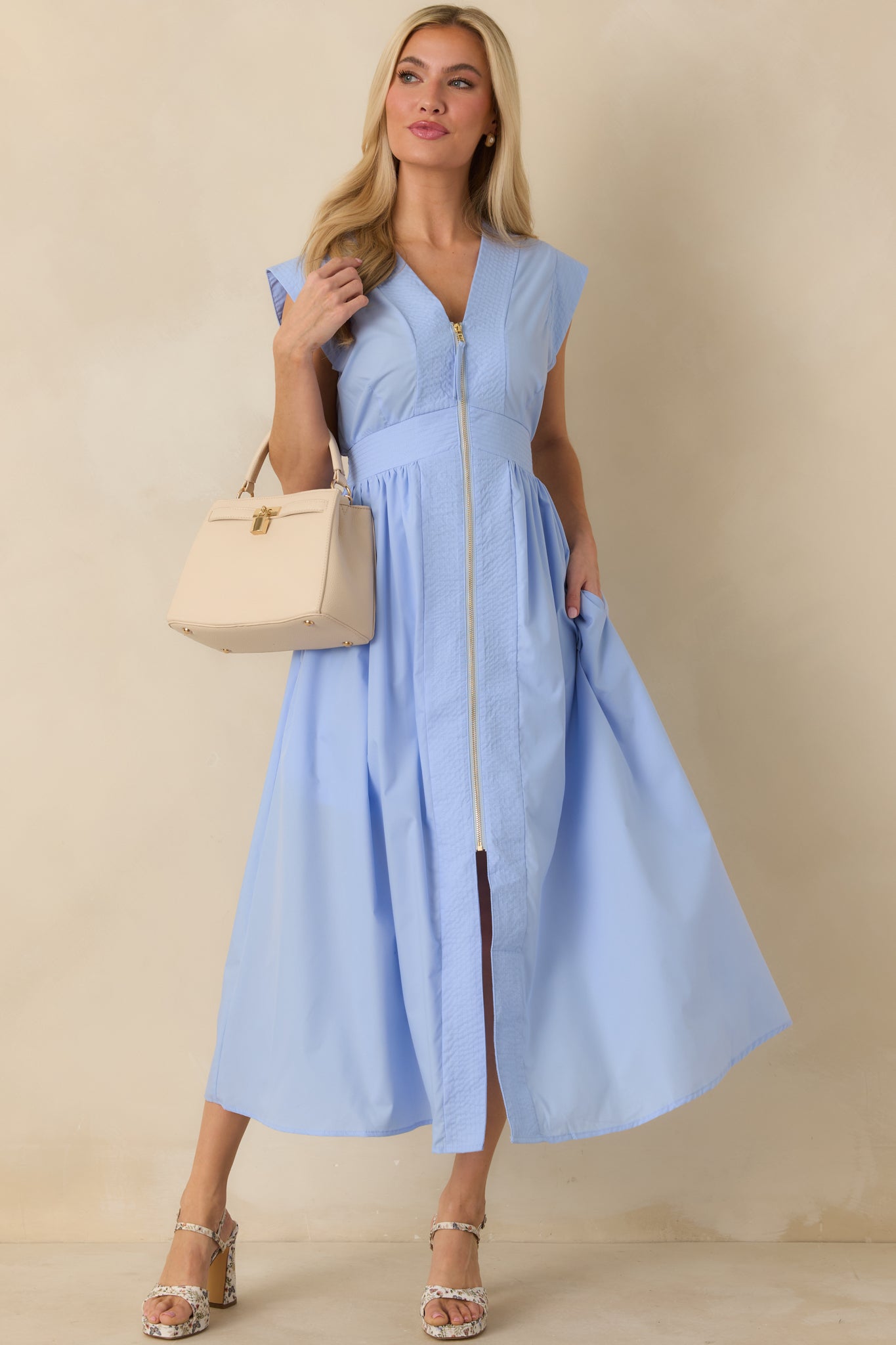 Full-length front view showcasing the fitted waist, lightly gathered skirt, and subtle sheen of the light blue fabric.