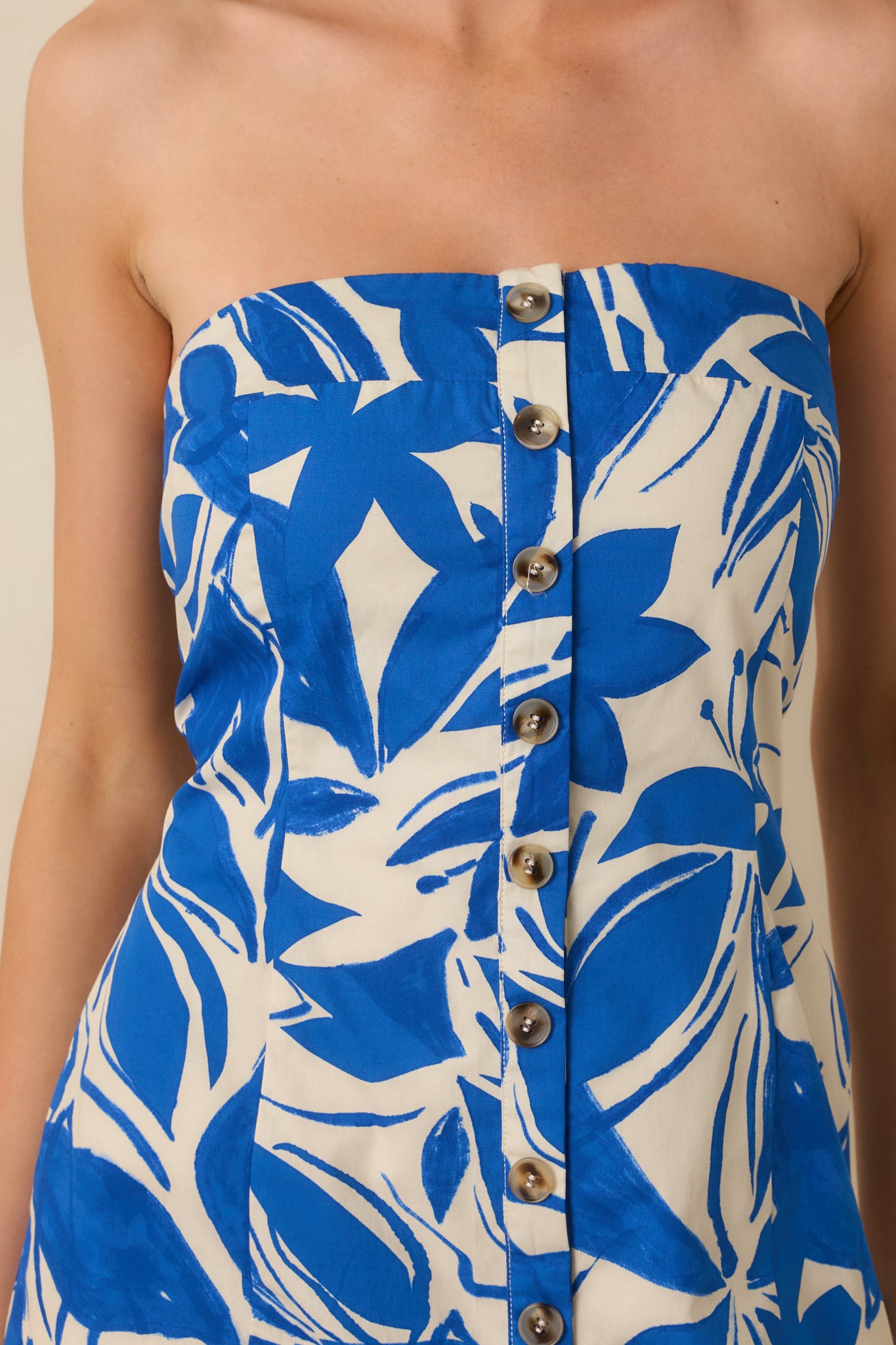 Functional button-front detail and structured fabric on blue and ivory mini dress.