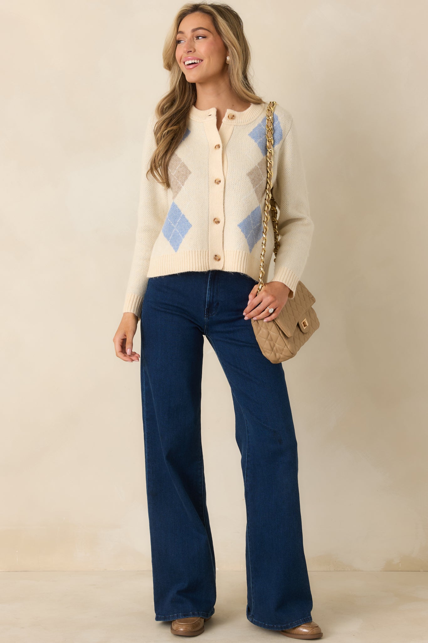 Functional button-front natural knit cardigan featuring soft blue and taupe argyle accents and a relaxed silhouette.