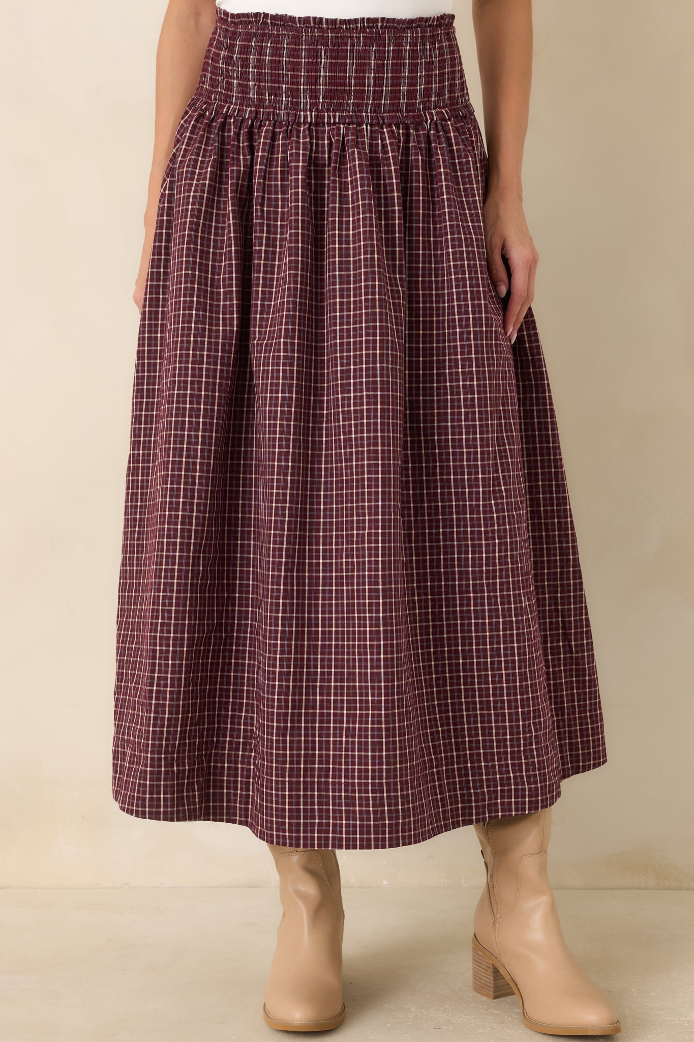 Detailed view showcasing the gathered cotton skirt, textured smocked waistband, and classic plaid pattern with rich burgundy and soft blue accents.