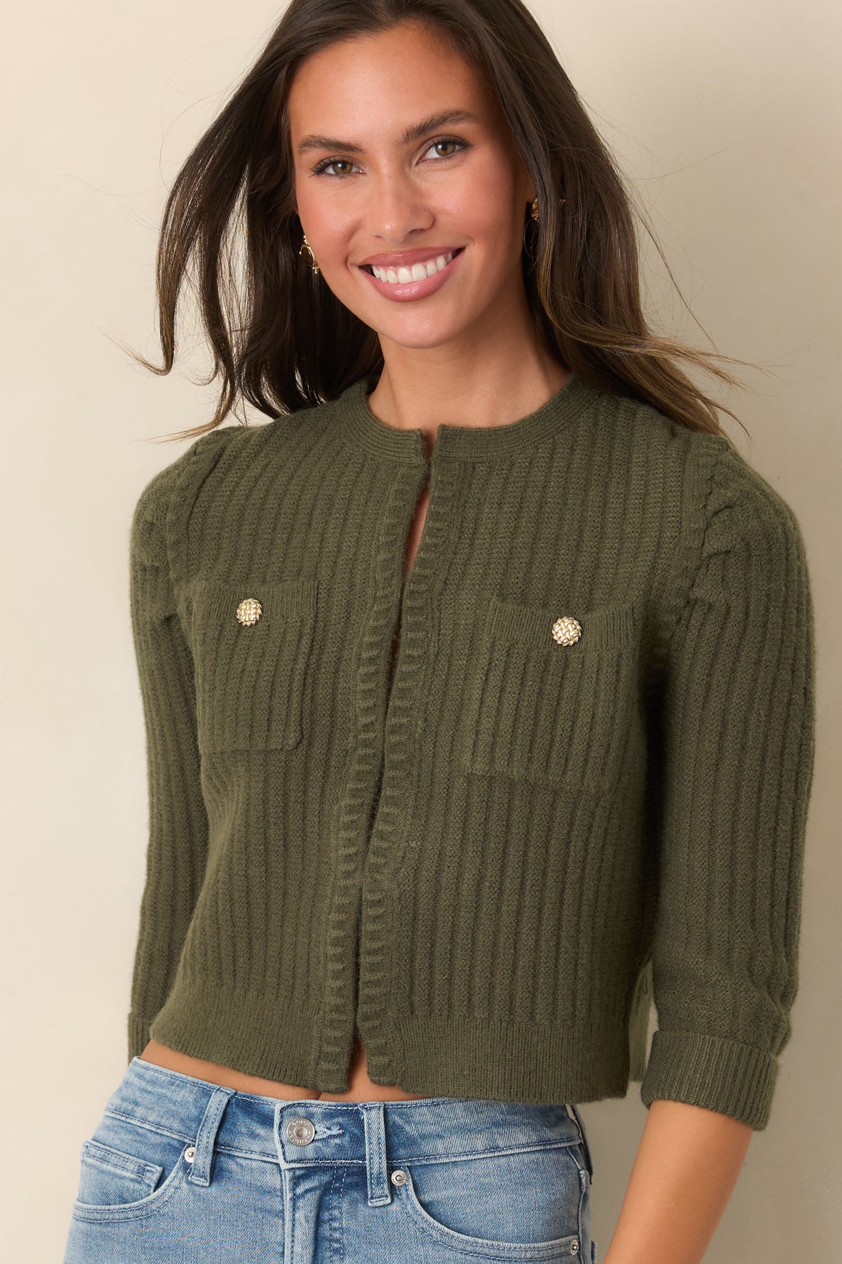 Gently gathered shoulders flow into three-quarter sleeves finished with ribbed cuffs.