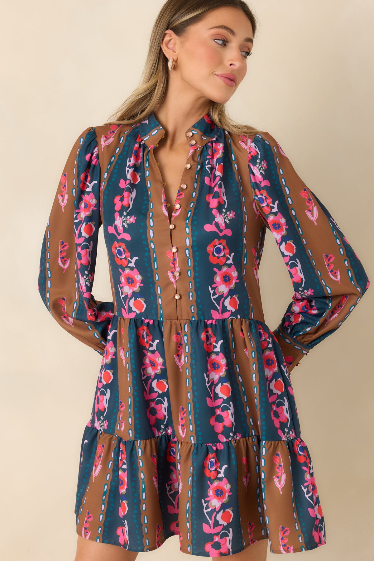 Long sleeves with softly gathered shoulders and wide cuffs complement the relaxed floral striped dress.