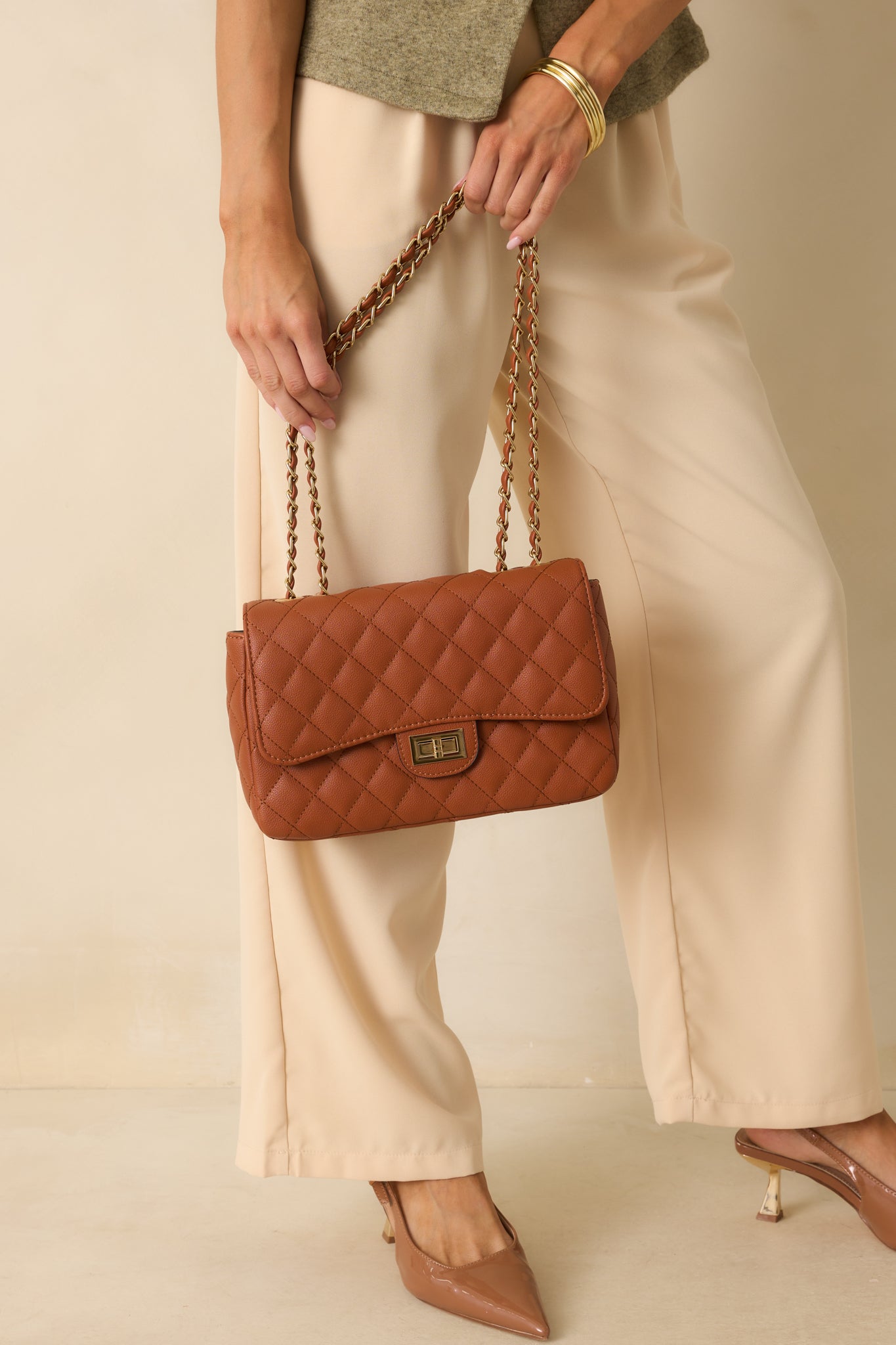 Ginger brown quilted handbag displayed front facing, featuring a twist-lock flap closure and chain shoulder strap that doubles as a crossbody.