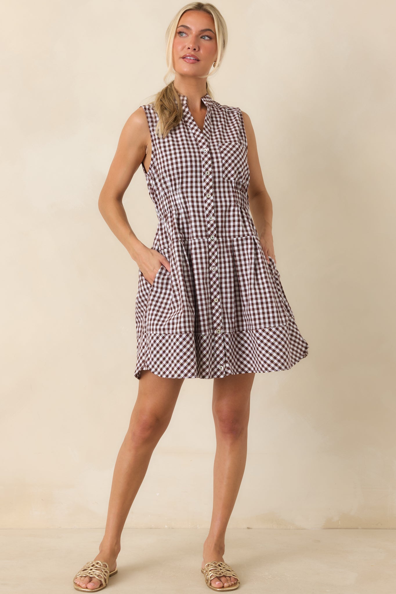 Gingham mini dress featuring a collared neckline, button-front placket, elastic waistband, and relaxed silhouette.