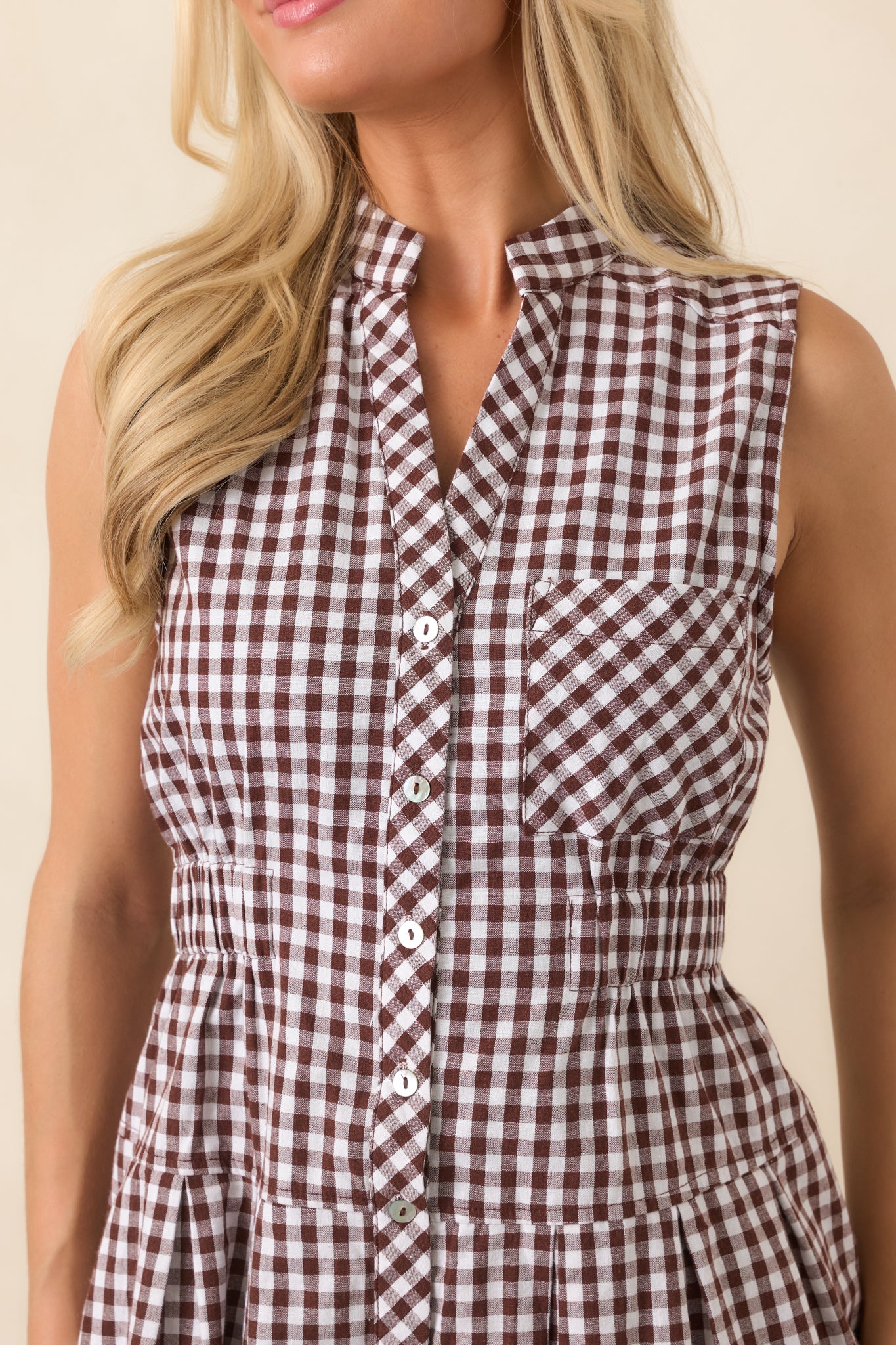 Close-up of the gingham dress revealing its crisp check pattern, collared neckline, button-front placket, and chest pocket.
