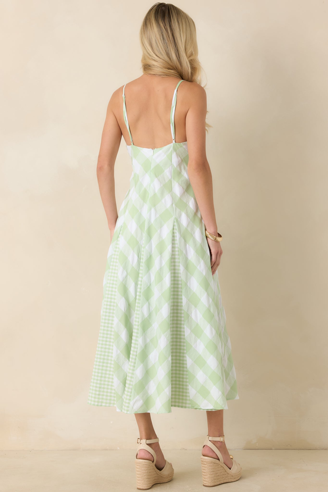 Back view of the gingham midi dress featuring adjustable spaghetti straps and a flowing A-line skirt.