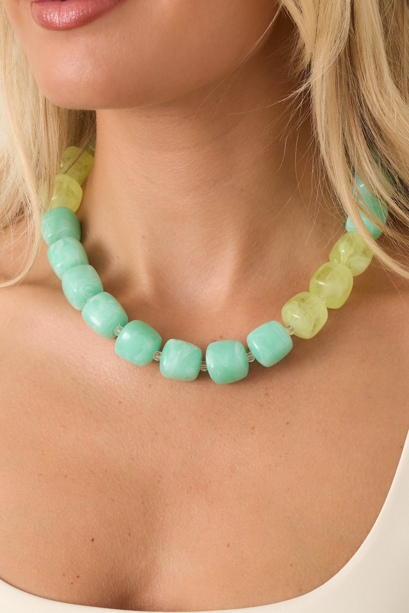 Statement necklace showcasing glossy resin beads, faceted details, and an adjustable gold-tone clasp closure.
