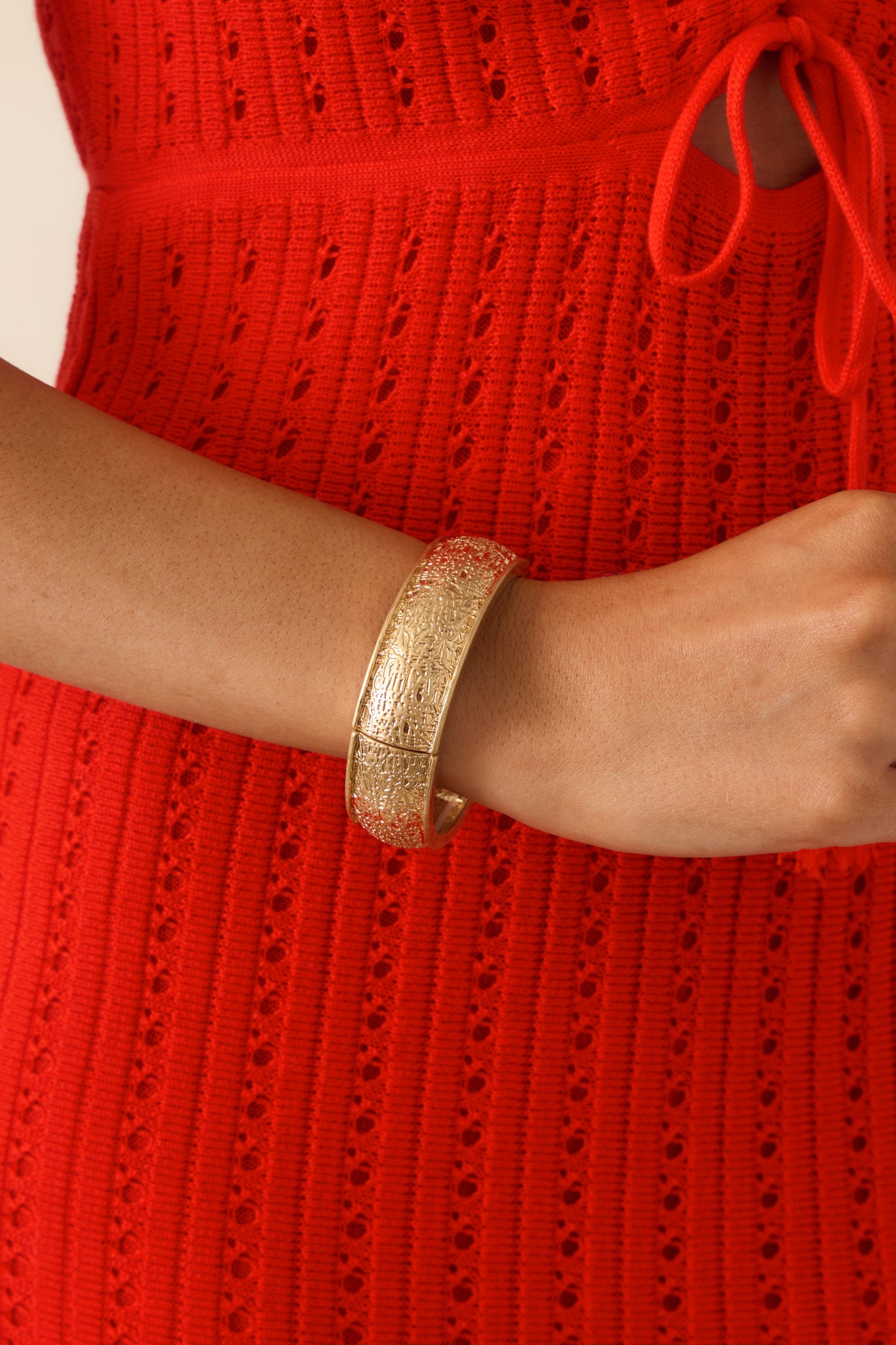 Gold bracelet featuring a heavily textured surface, dimensional design, and flexible elastic stretch bands.