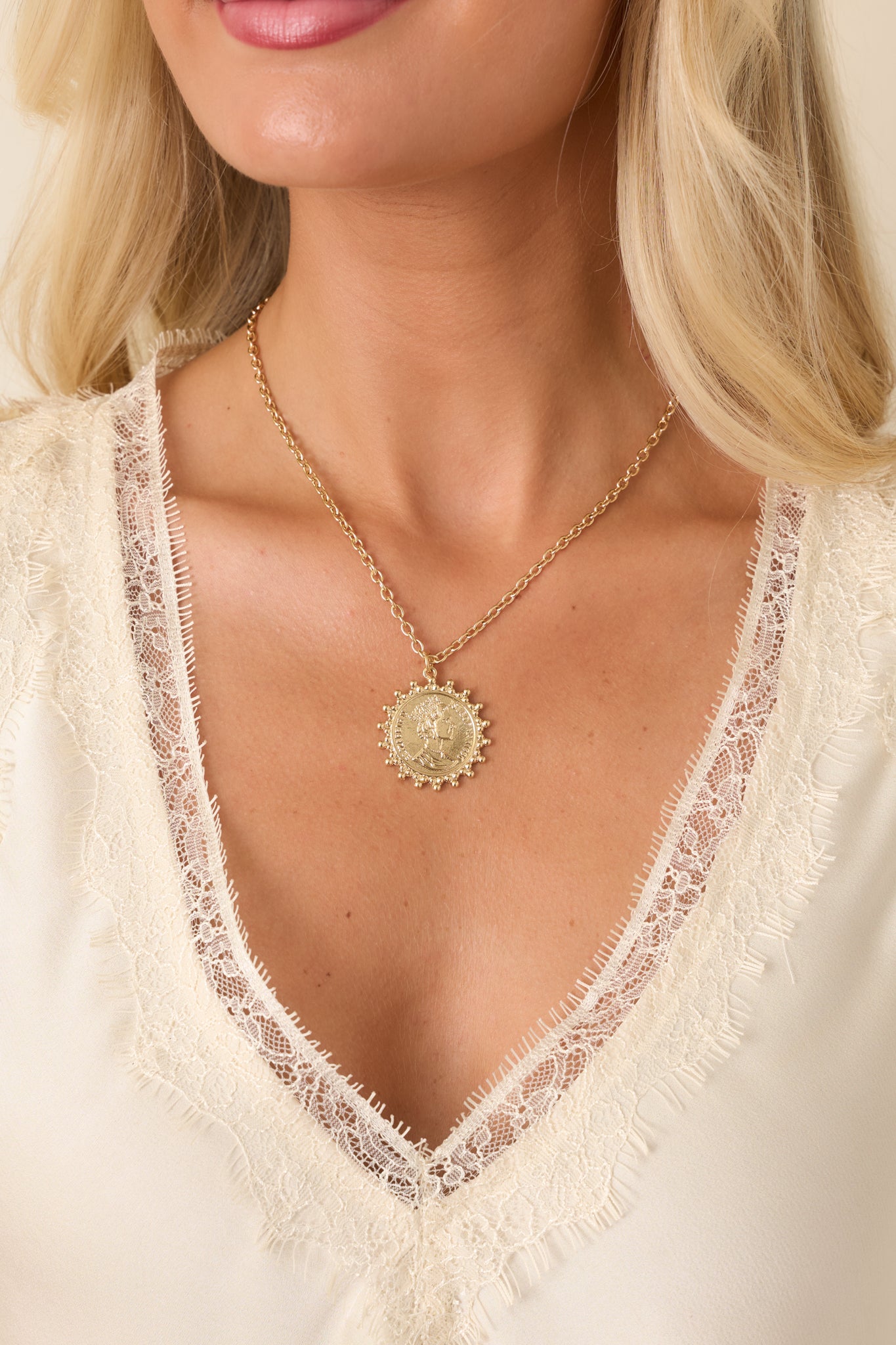 Gold coin pendant necklace featuring a detailed circular charm, beaded border, polished chain, and classic design for versatile styling.