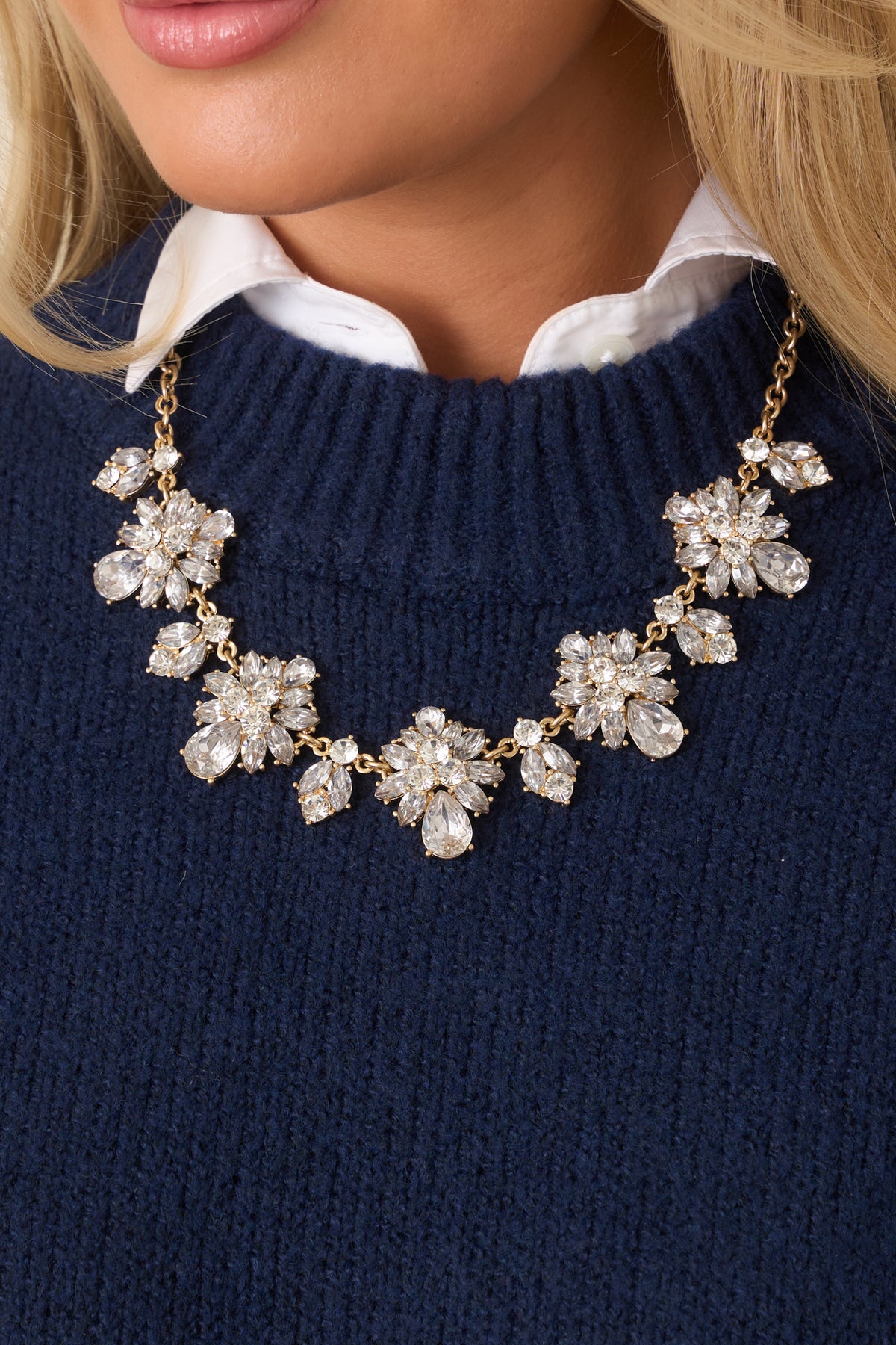 Gold necklace with a medium-thick chain and chunky rhinestone pendants arranged along the links.