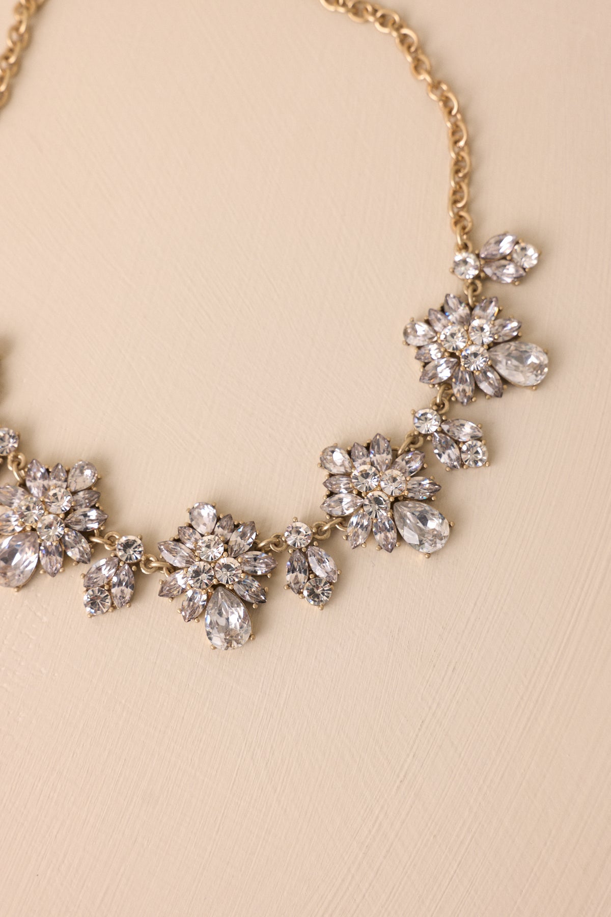 Close-up of chunky rhinestone pendants and gold hardware along the necklace chain.
