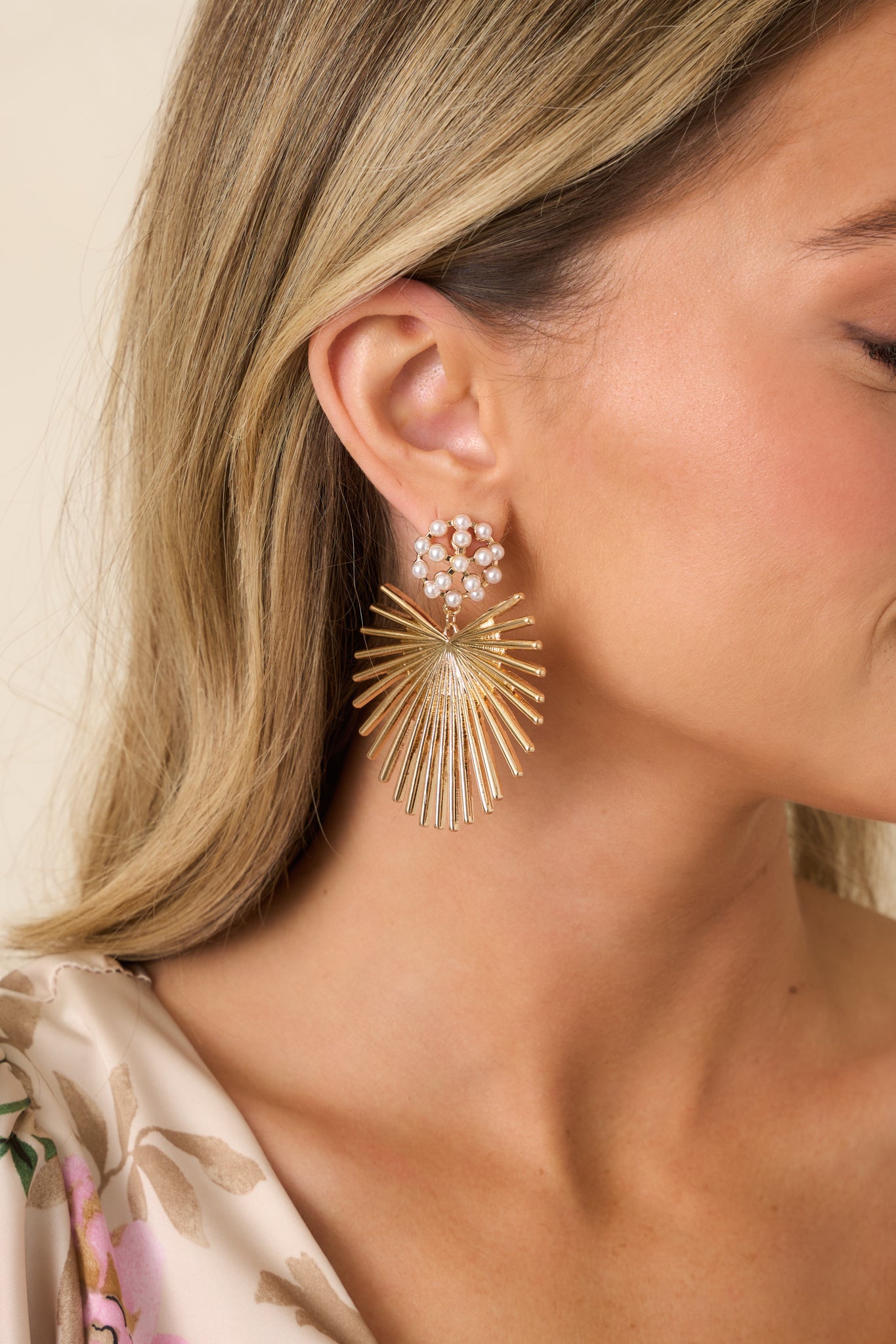 Gold and pearl drop earrings featuring clustered faux pearl studs and a lightweight sunburst design.