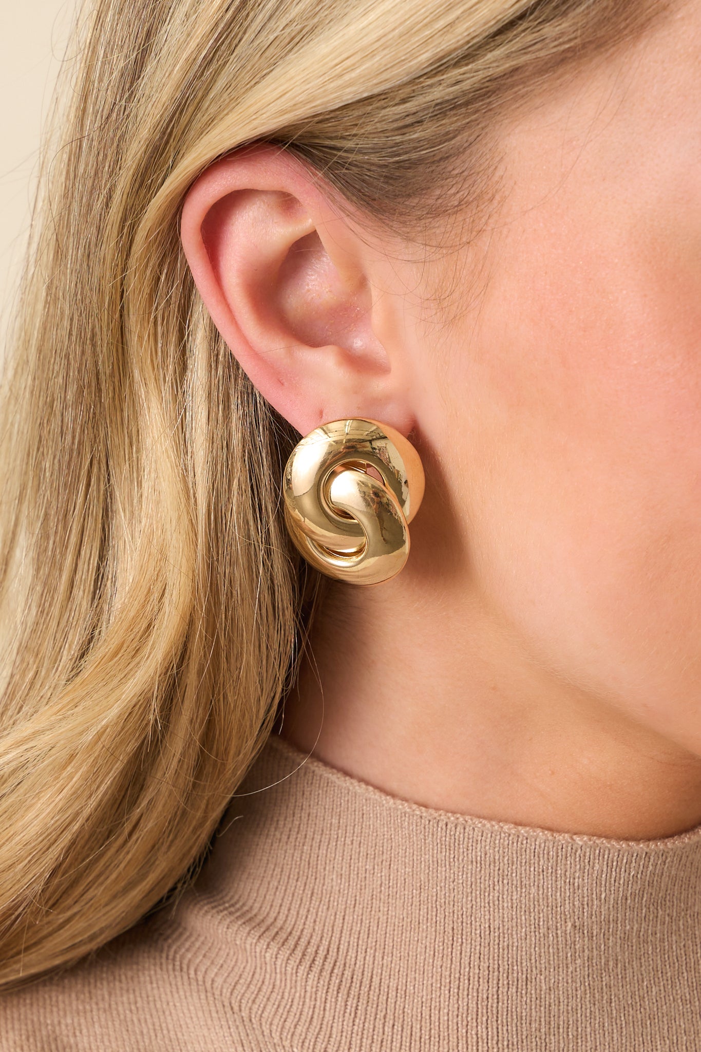 A close-up detail of one earring, showcasing the interlocked circular links and secure post backing with clear texture and finish.
