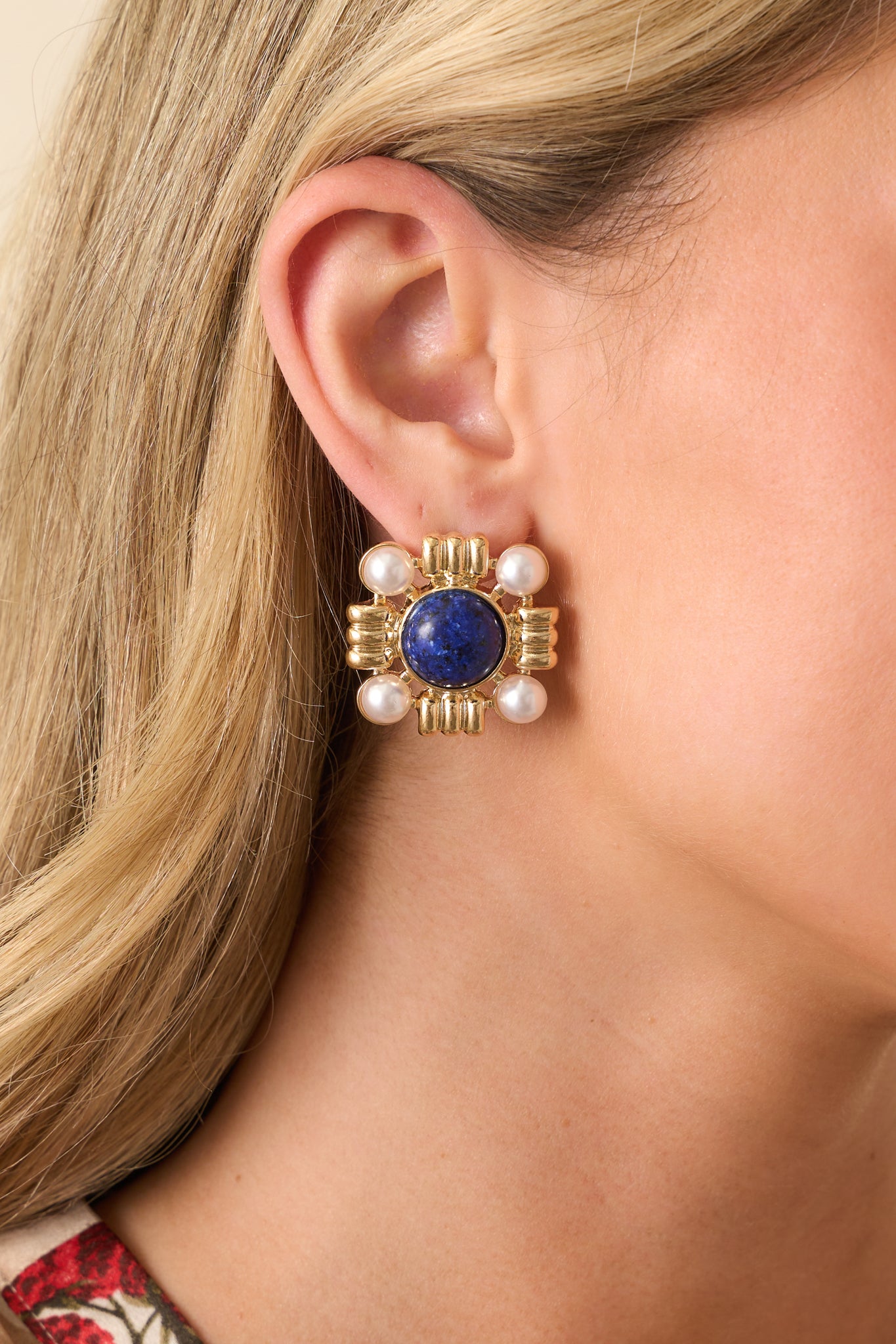 An extreme close-up capturing the marble-like texture of the navy stone, the luster of the faux pearls, and the intricate gold accents.