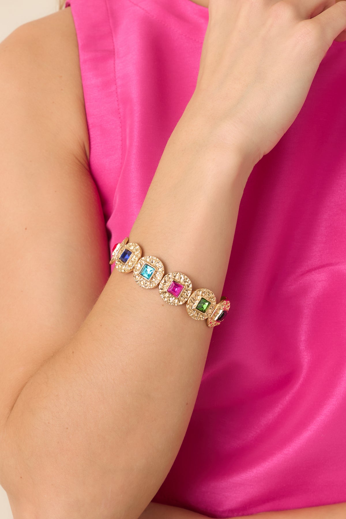 Gold-tone bracelet featuring ornate medallions with colorful square crystals in pink, aqua, green, red, and deep blue.