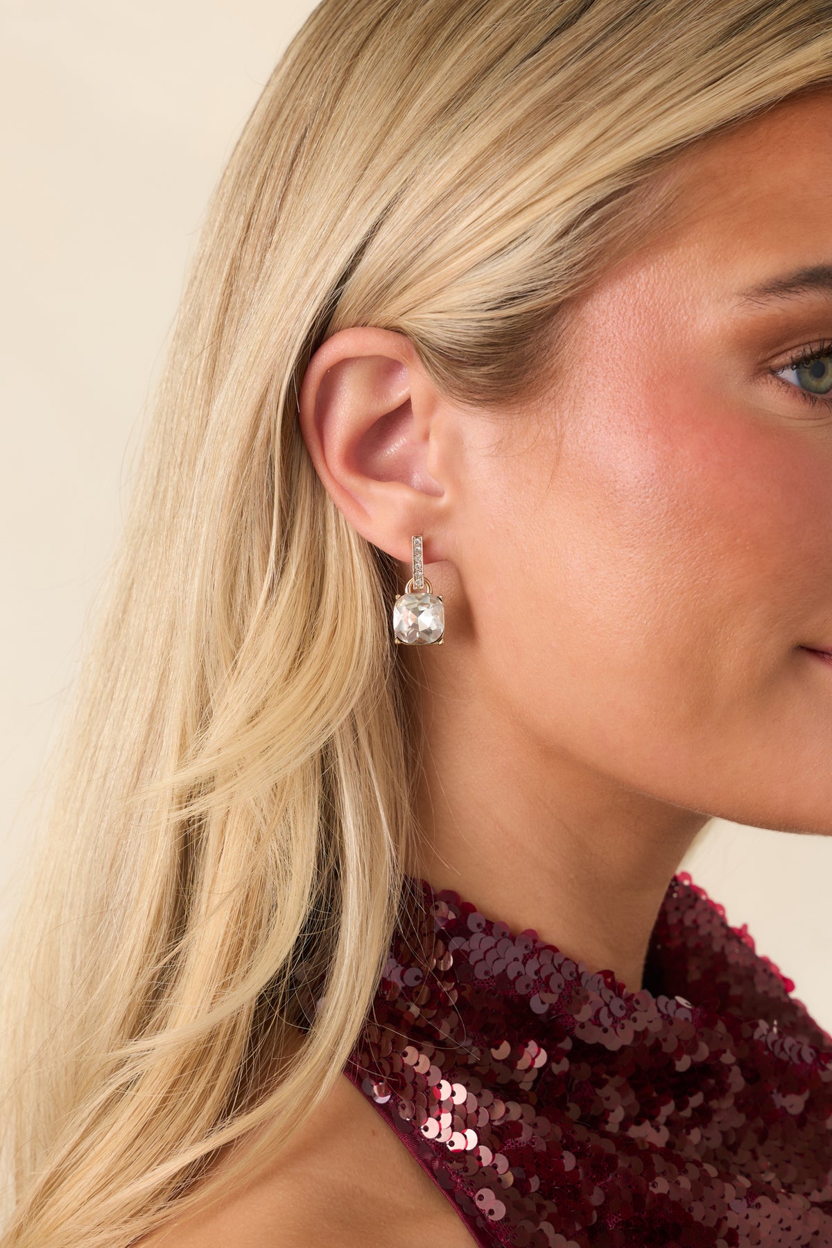 Elegant gold-tone earrings featuring sparkling rectangular crystal bars above faceted clear gemstones.