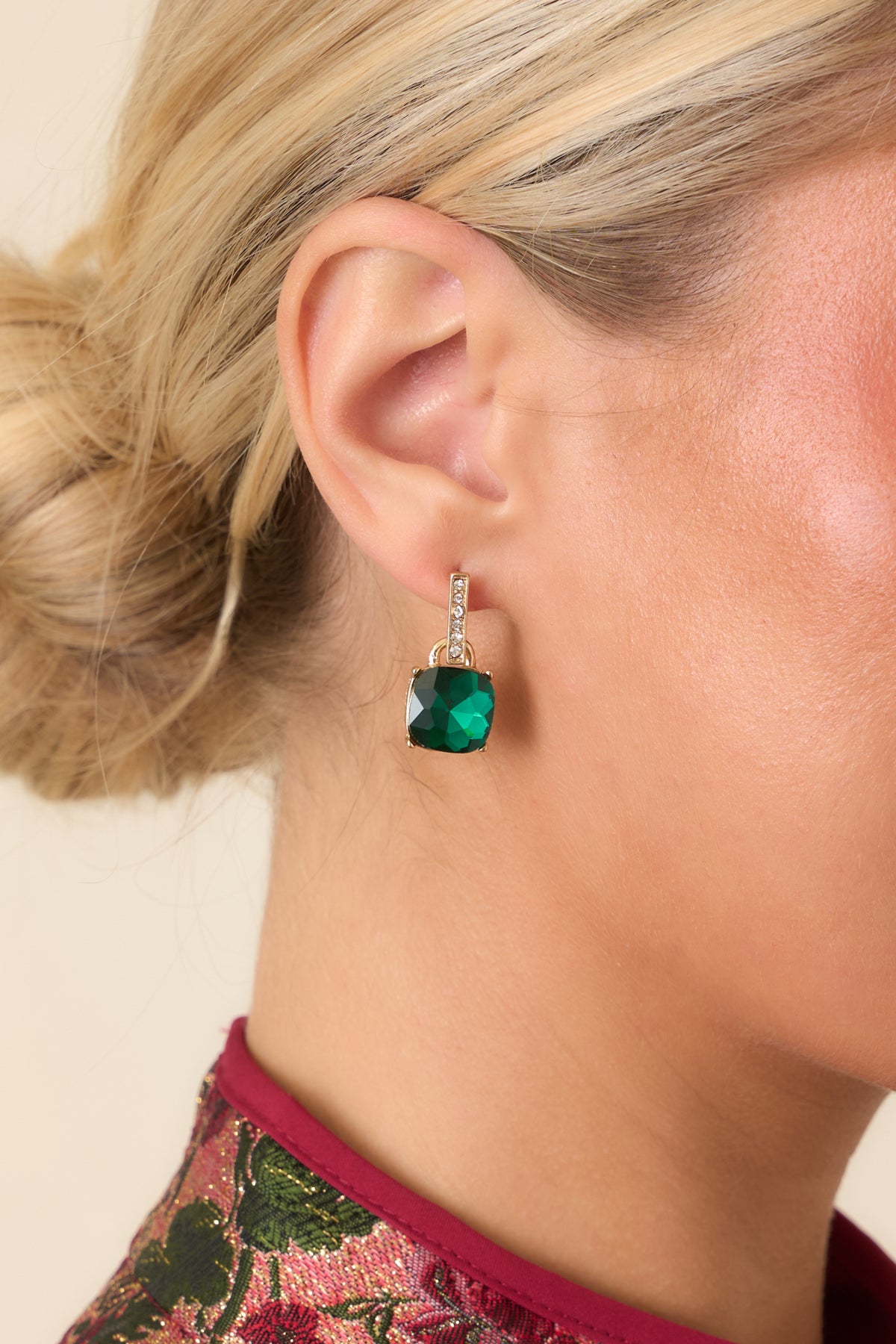 Gold-tone drop earrings with sparkling crystal bars and cushion-cut emerald green stones.