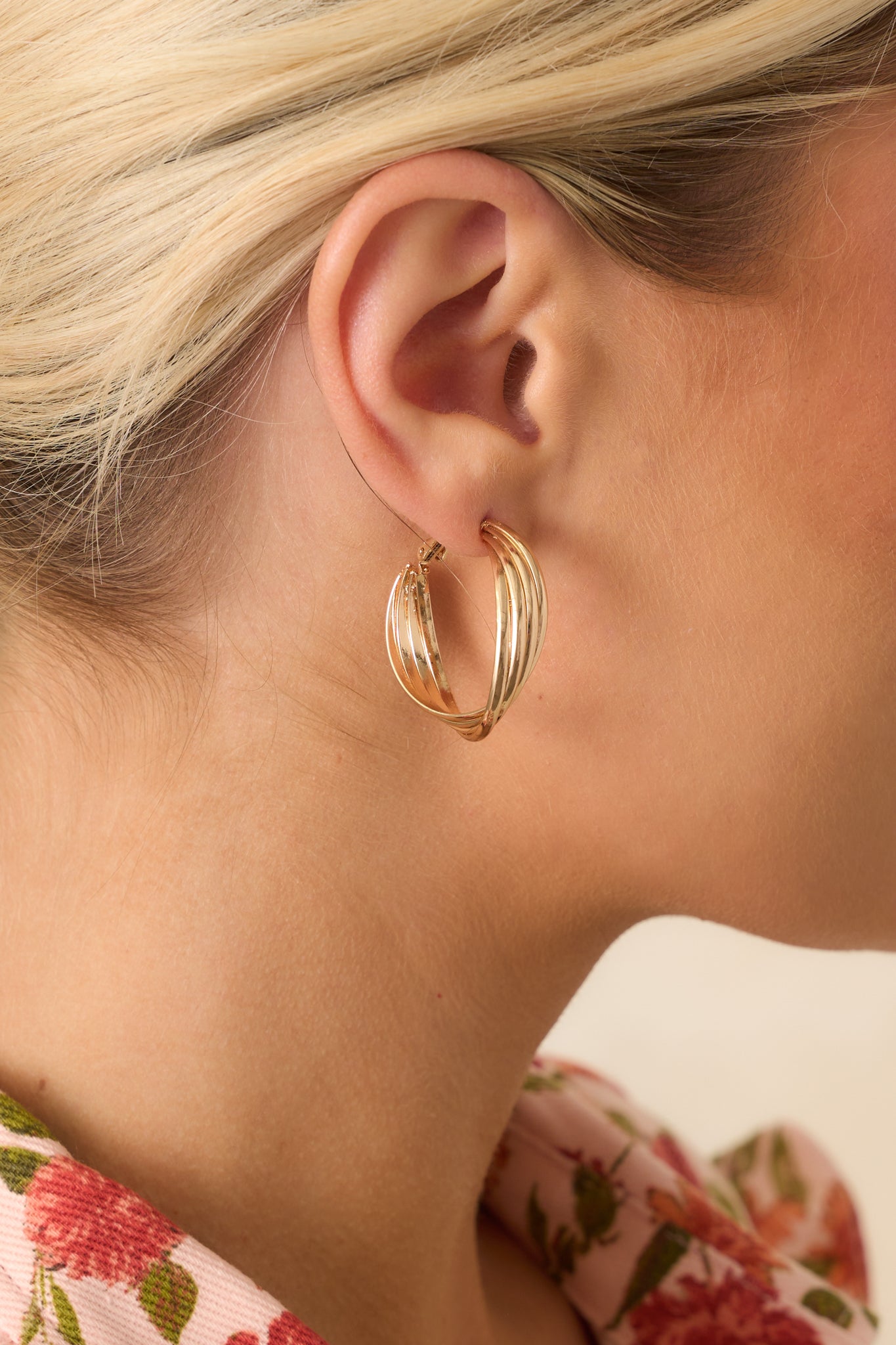 An extreme close-up capturing the intricate overlapping hoops, smooth metallic texture, and fine detail of the gold closure.