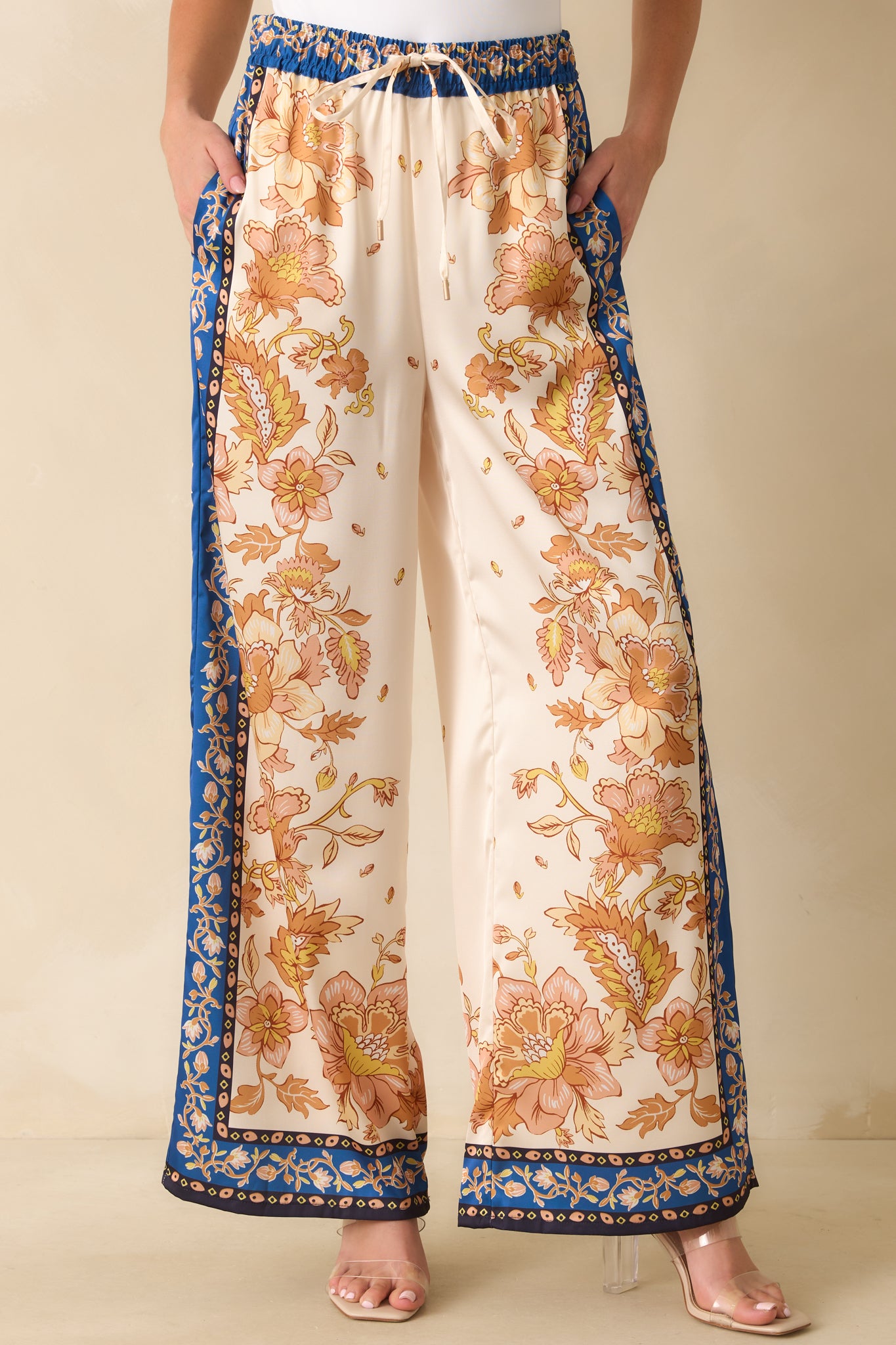 Detail of the golden yellow floral pattern on ivory satin fabric with functional front pocket.