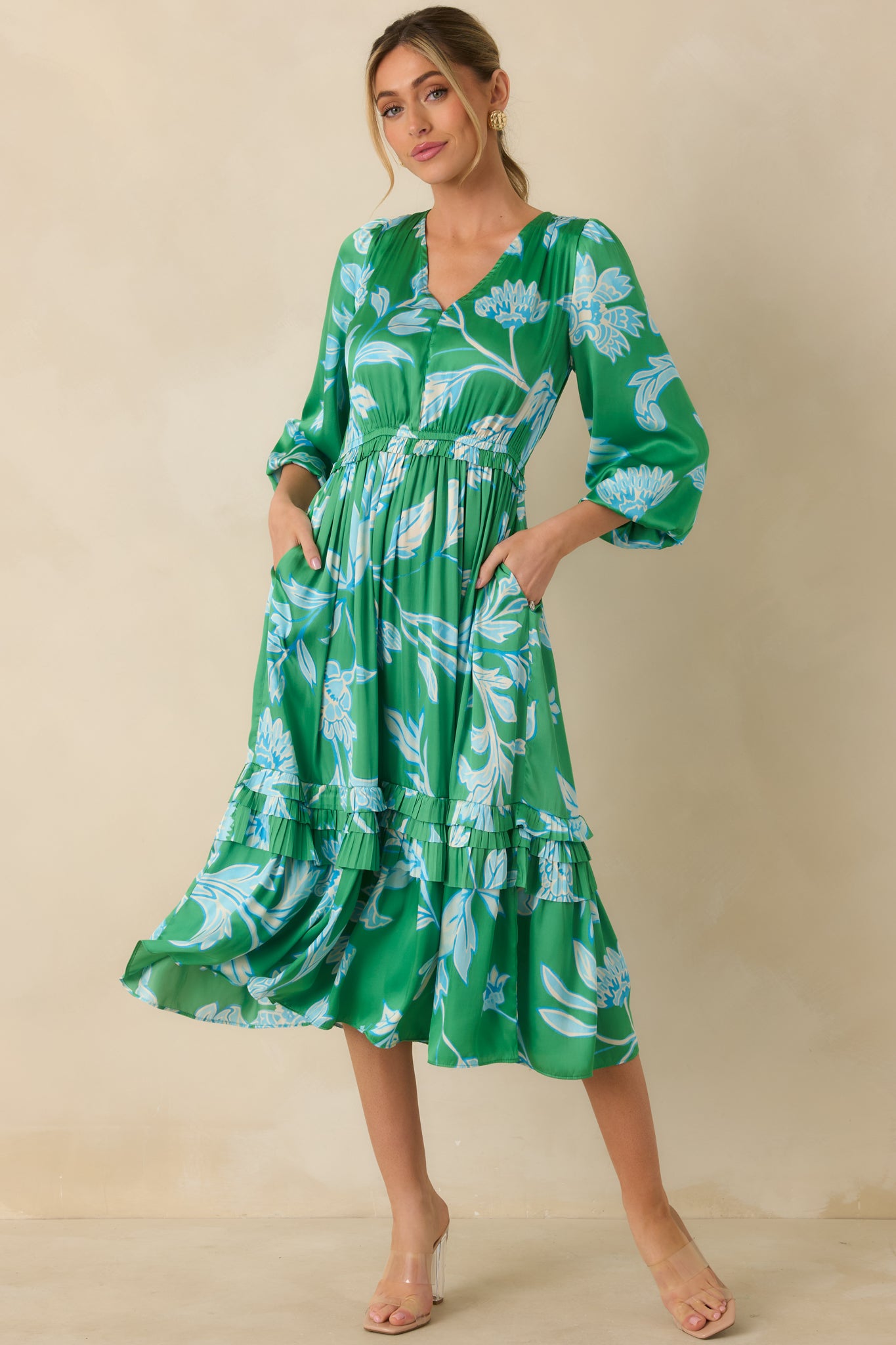Front-facing angle of green and blue midi dress highlighting 3/4-length balloon sleeves and functional side pockets.