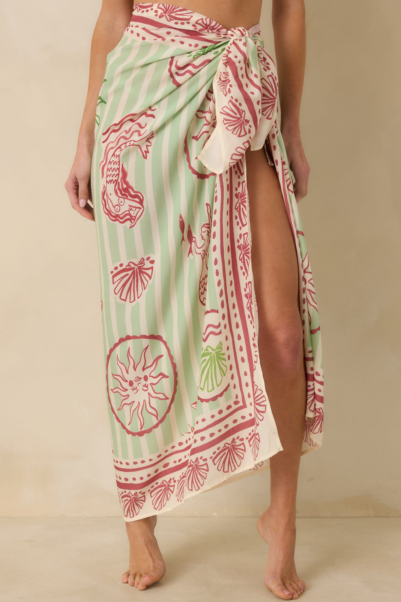 Cropped front view of green and pink sarong highlighting adjustable wrap tie and lightweight woven texture.