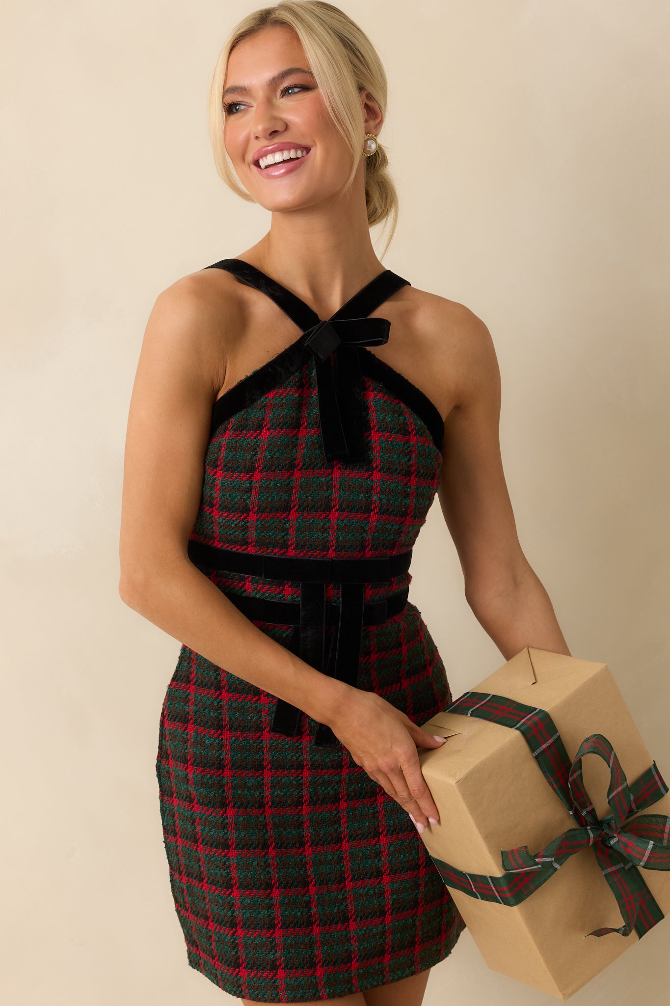 Green and red plaid tweed mini dress with a halter-style neckline and adjustable velvet straps above a fitted bodice.