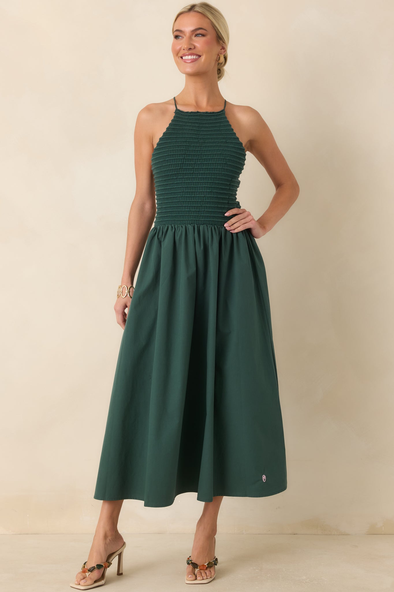 Green cotton midi dress featuring a fitted knit bodice, high halter neckline, and a flowing midi-length skirt for an effortlessly elegant silhouette.