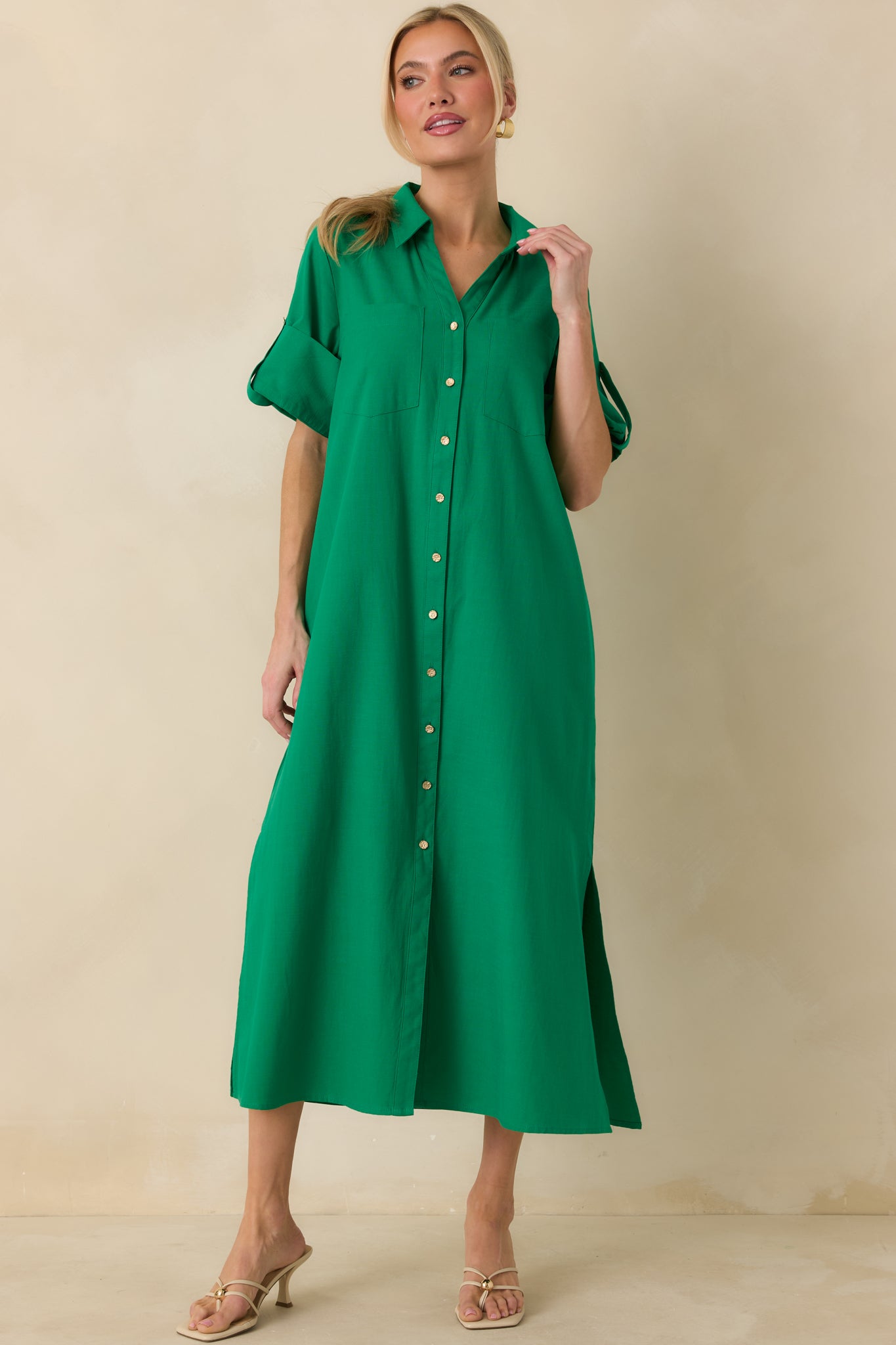 Front-facing angle of green cotton midi shirt dress highlighting long sleeves and draped straight fit.