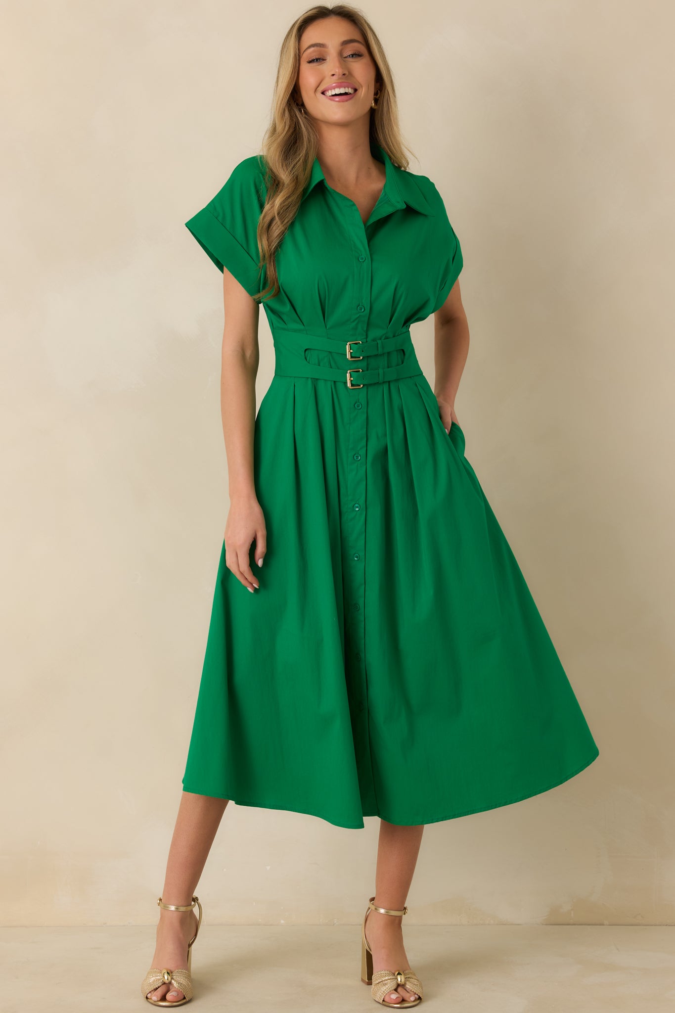 Green midi dress with short sleeves, button front closure, and a softly draped skirt falling below the knees.