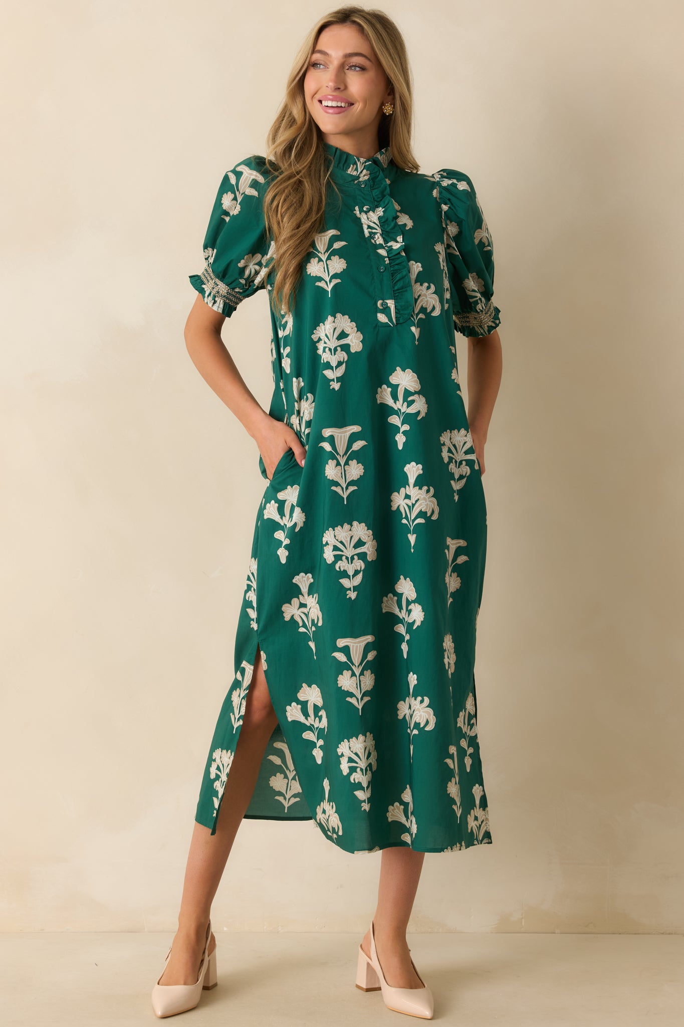 Green maxi dress with an ivory floral print, puff sleeves, and a ruffled mock neckline for a soft, feminine look.