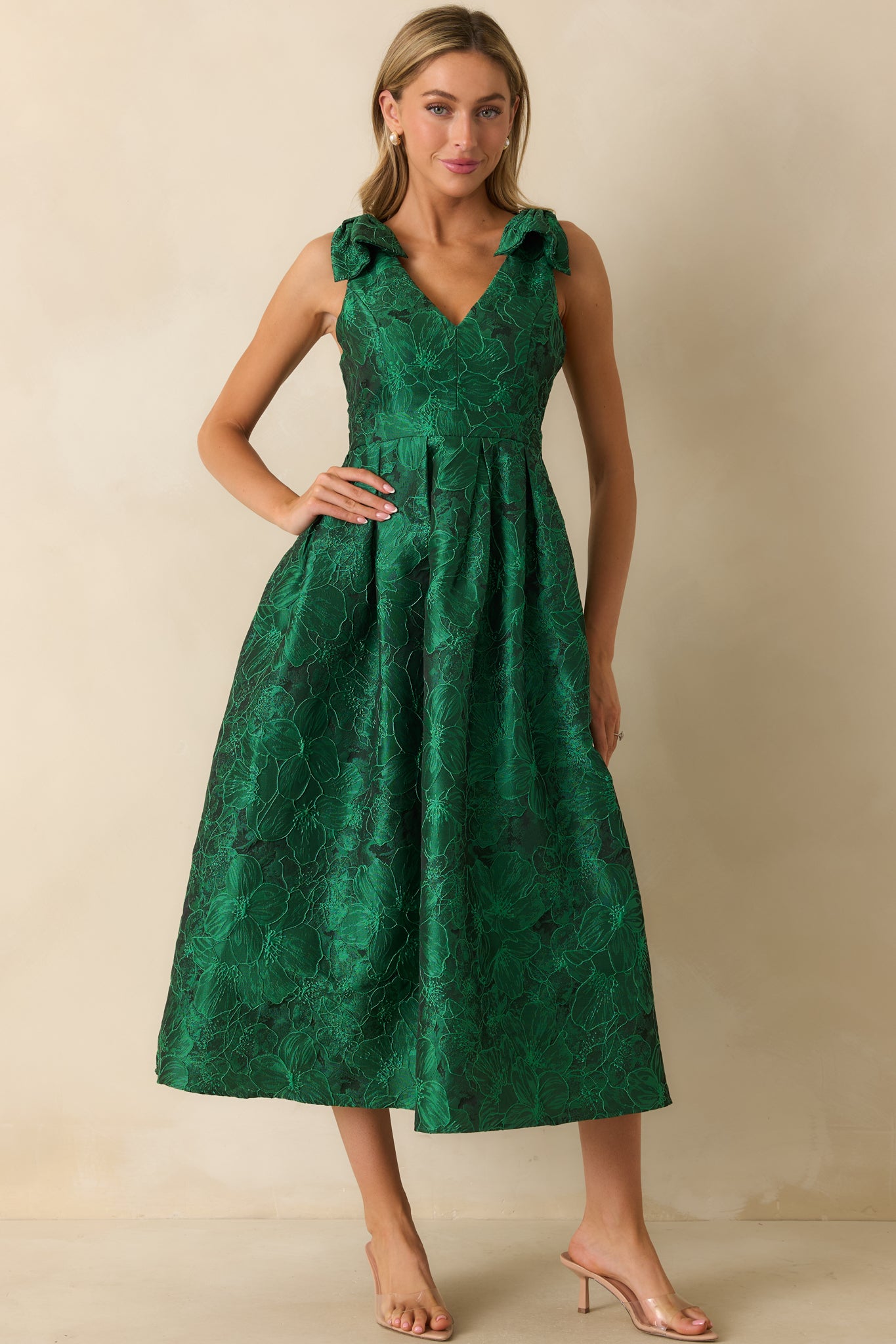 Relaxed-fit green midi dress showcasing sleeveless cut, v-neckline, and floral pattern with side pockets.