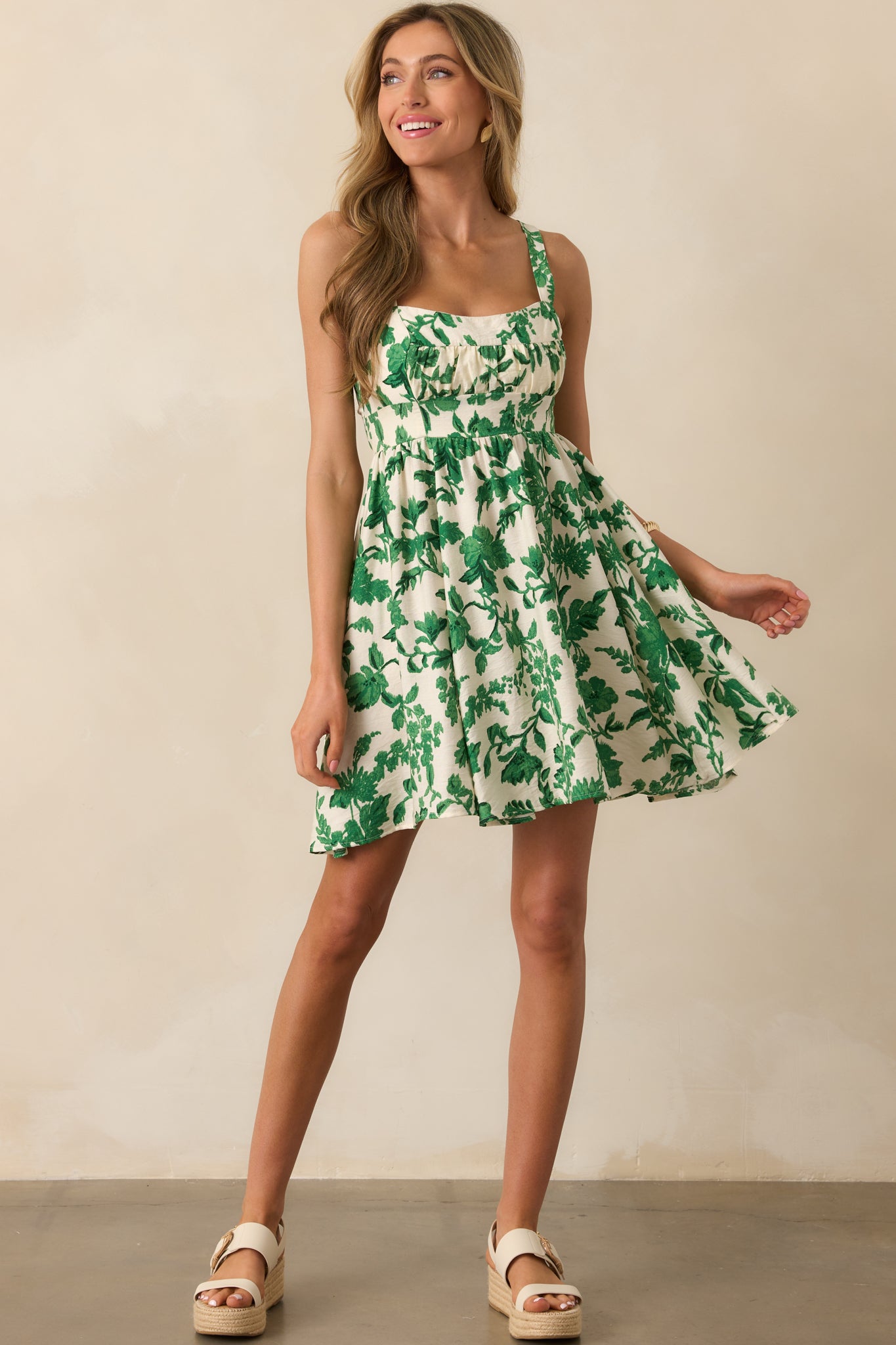 Green floral mini dress with a scoop neckline and ruched bust panel, shown in a full body front view.