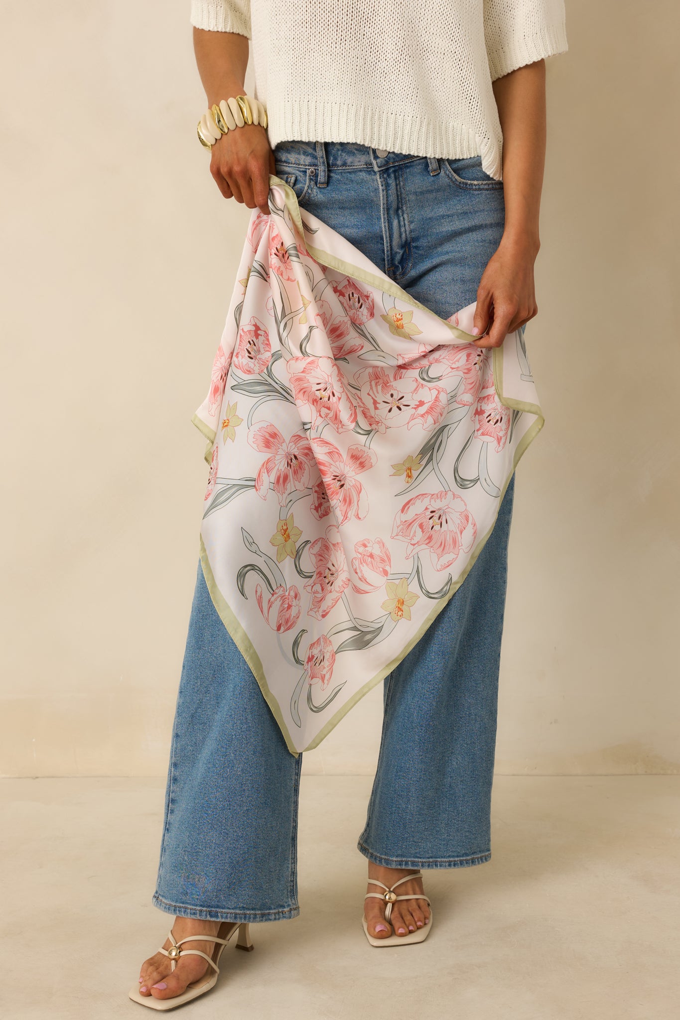 Partial view of the green floral scarf focusing on ivory background and flowing botanical pattern.