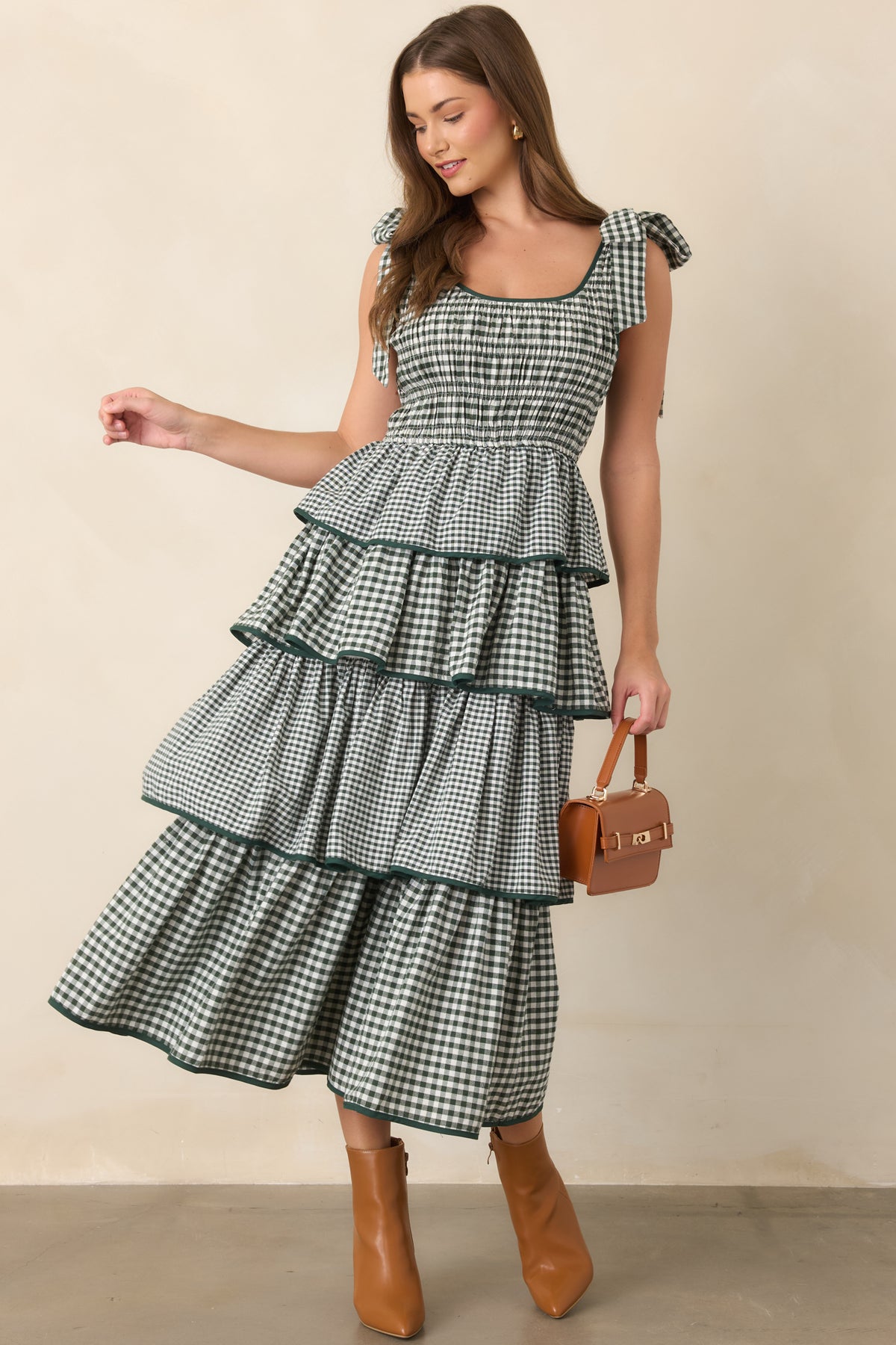 Flowing green dress defined by four tiers, coordinating edge trim, fixed shoulder ties, and a flattering elasticized waist.