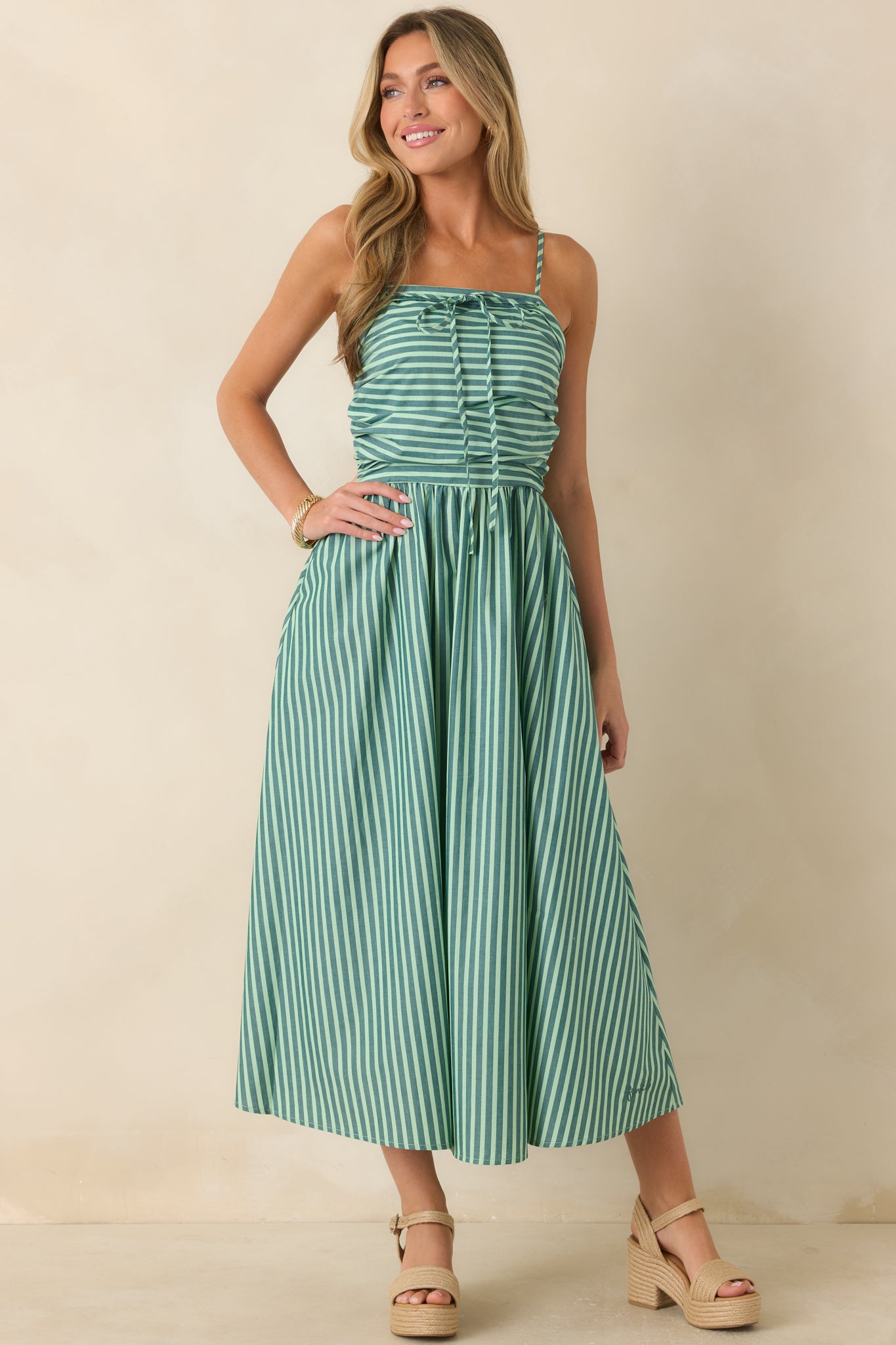 Green and ivory cotton maxi dress with a flattering straight neckline, gathered waist, side pockets, and a flowing silhouette.