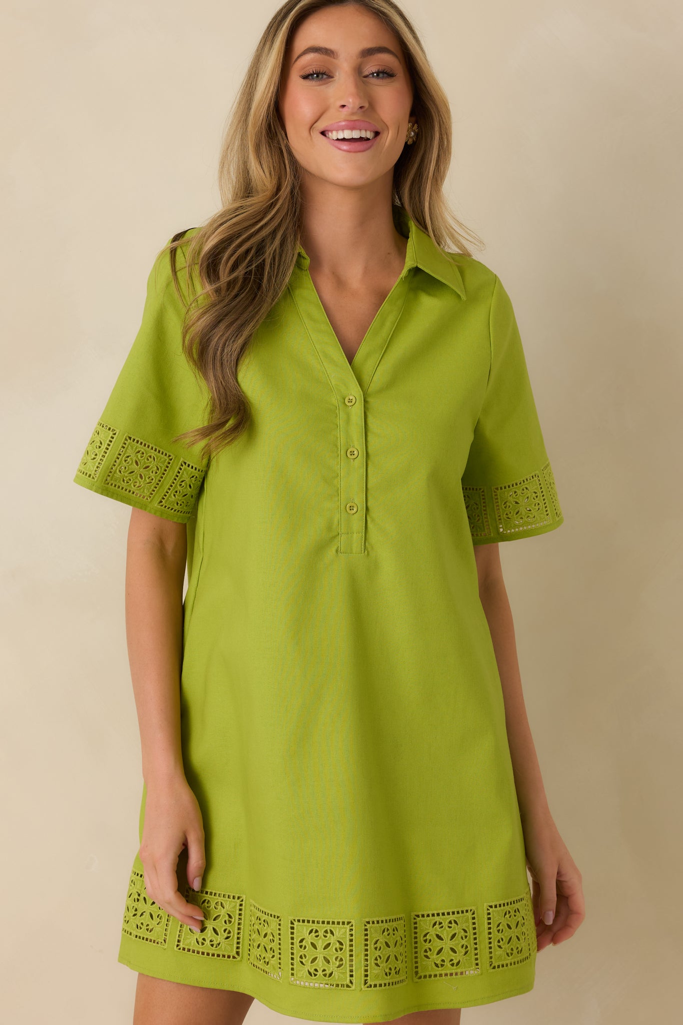 Cropped front view focusing on the collared neckline and partial button-front closure of the green mini dress.